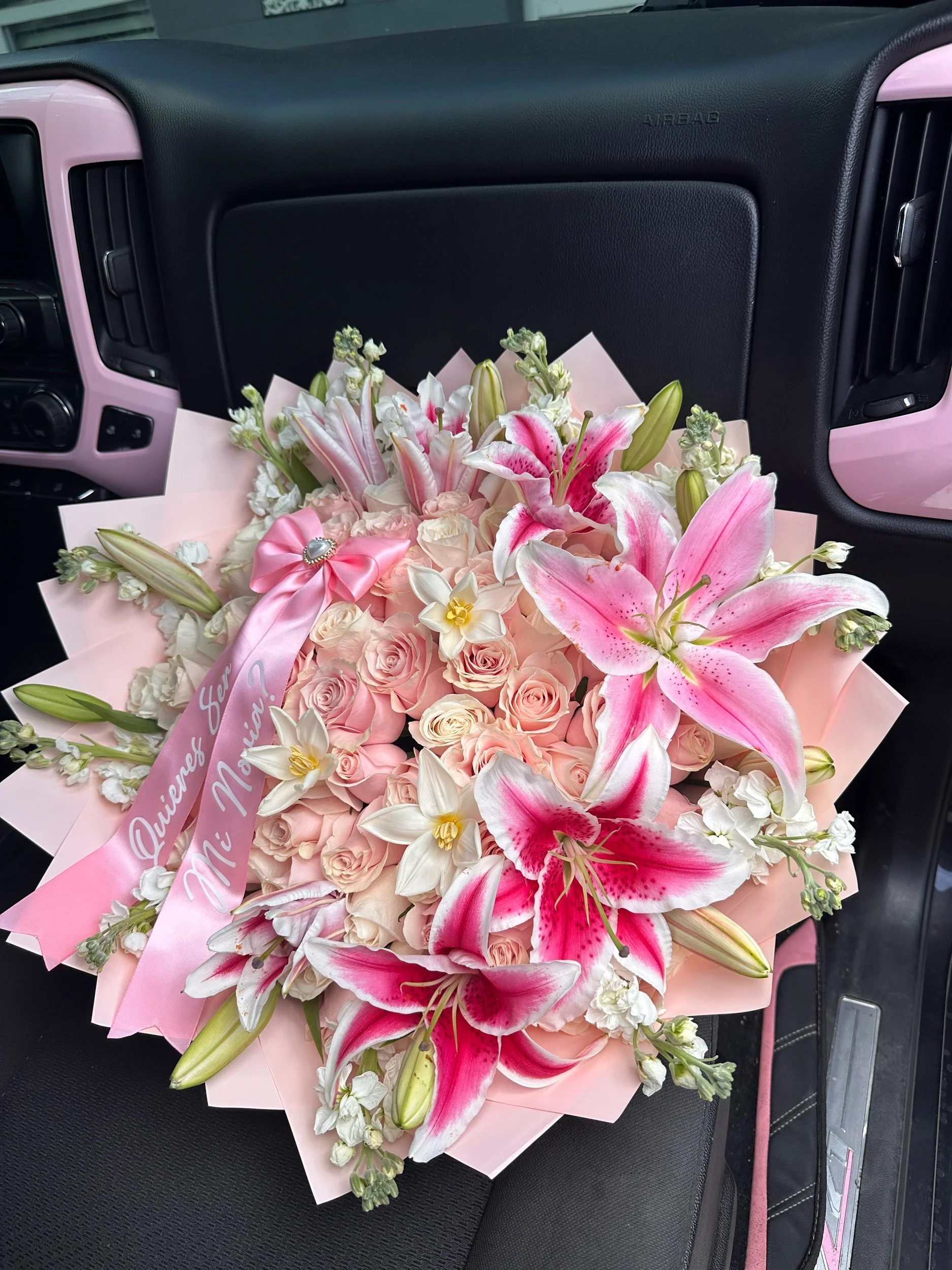Pink rose bouquet with lilies, stock, tulips, and a decorative message bow.