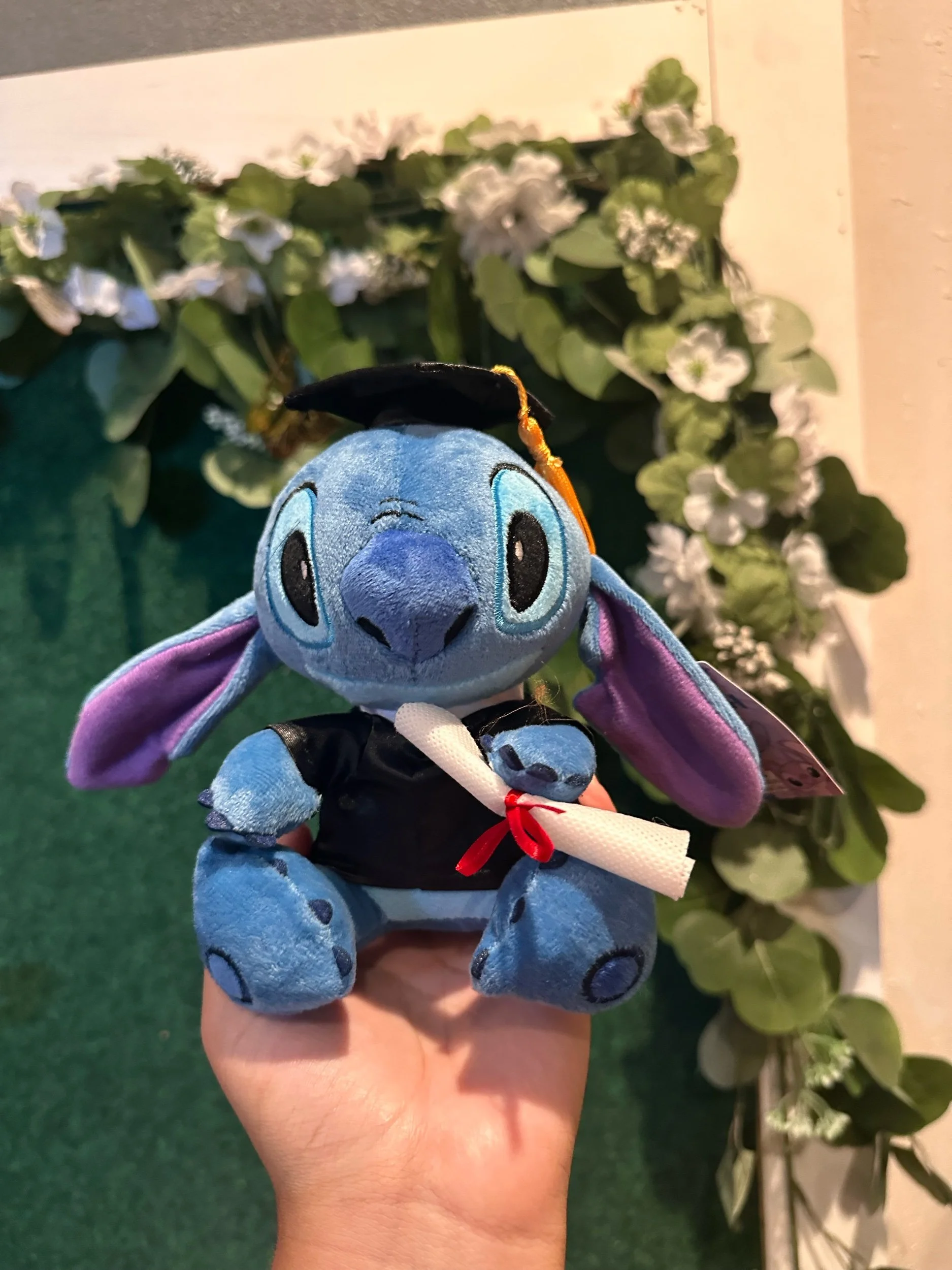 Blue Stitch graduation plush wearing a graduation cap.