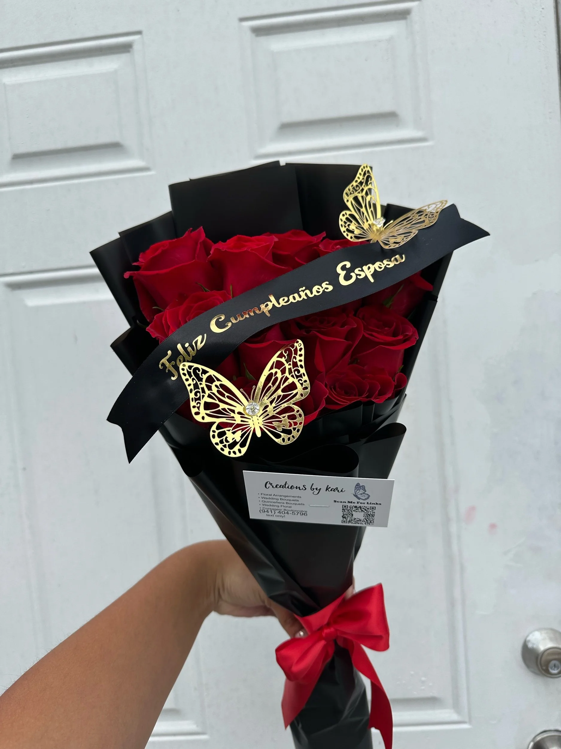Red rose bouquet with a message banner and decorative gold butterflies