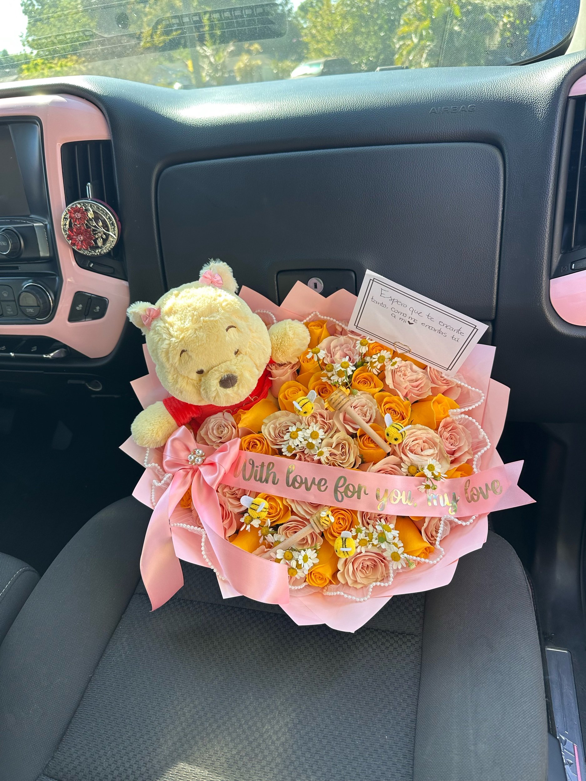 Pink and yellow rose bouquet with chamomile, honey sticks, decorative bees, Winnie the Pooh plush, pearl mesh, and pink floral wrapping.