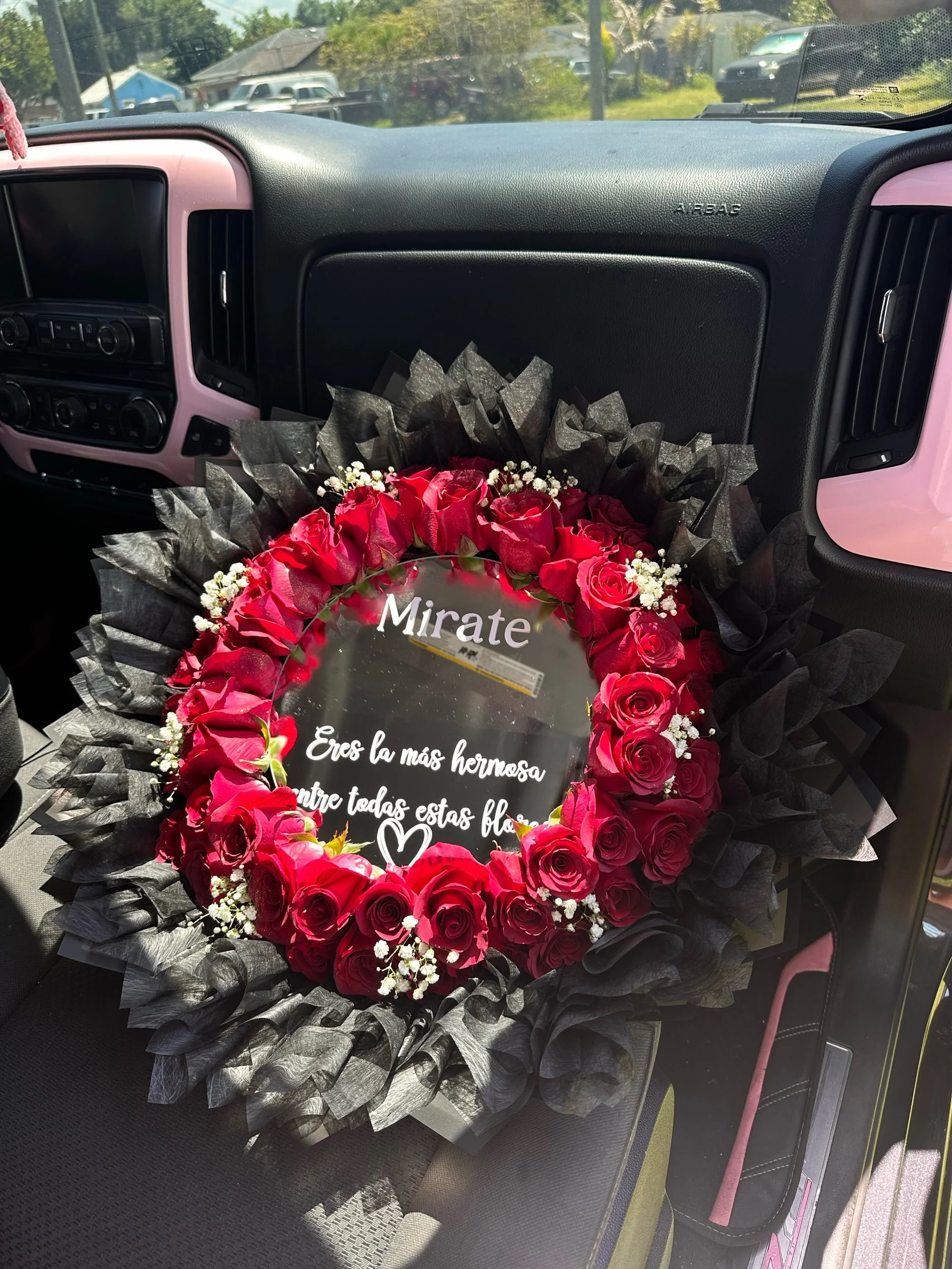 Red rose bouquet with baby’s breath clusters, black tissue, and a personalized message mirror.