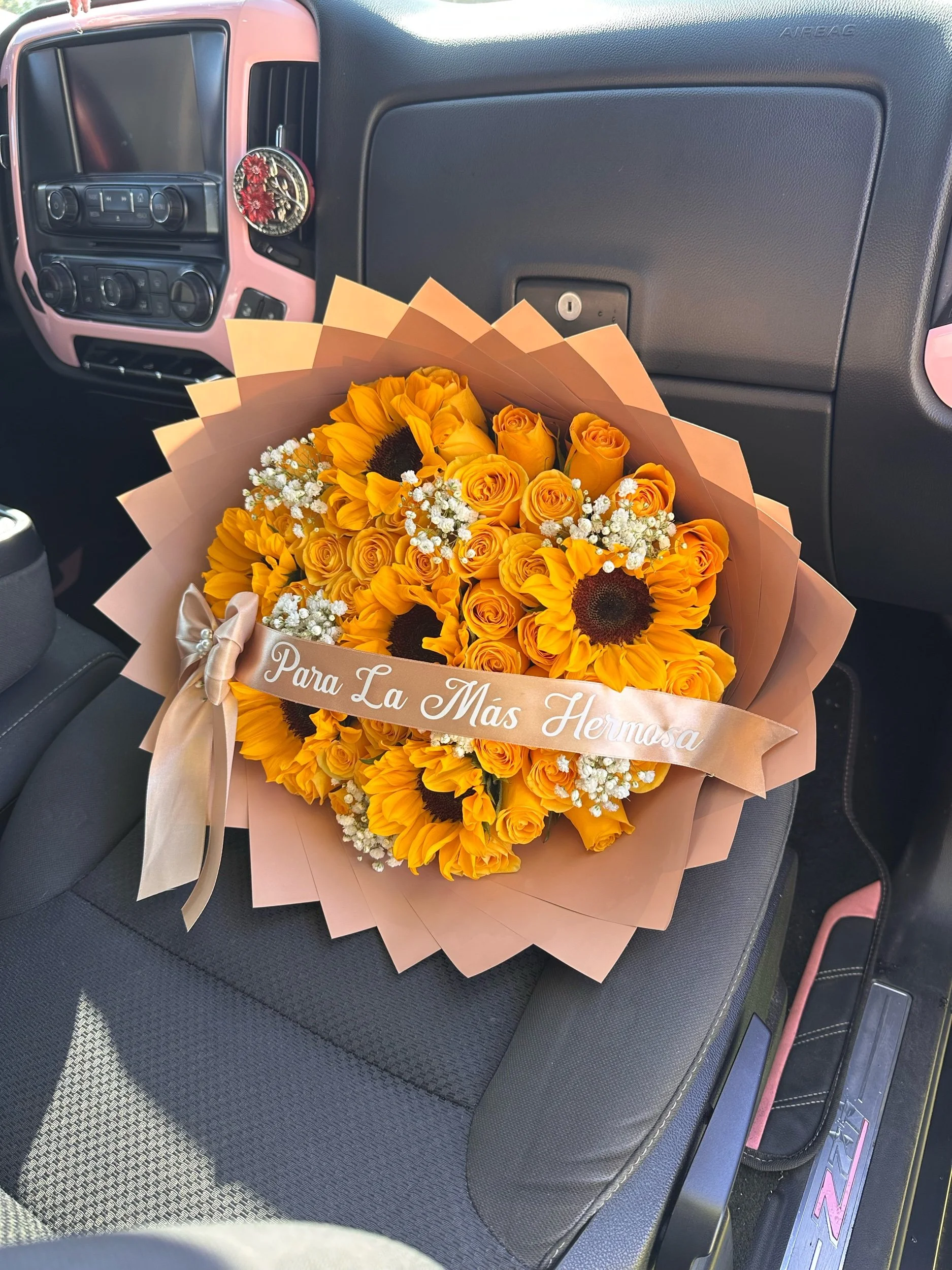Bright yellow rose and sunflower bouquet accented with clusters of white baby’s breath and a message banner.