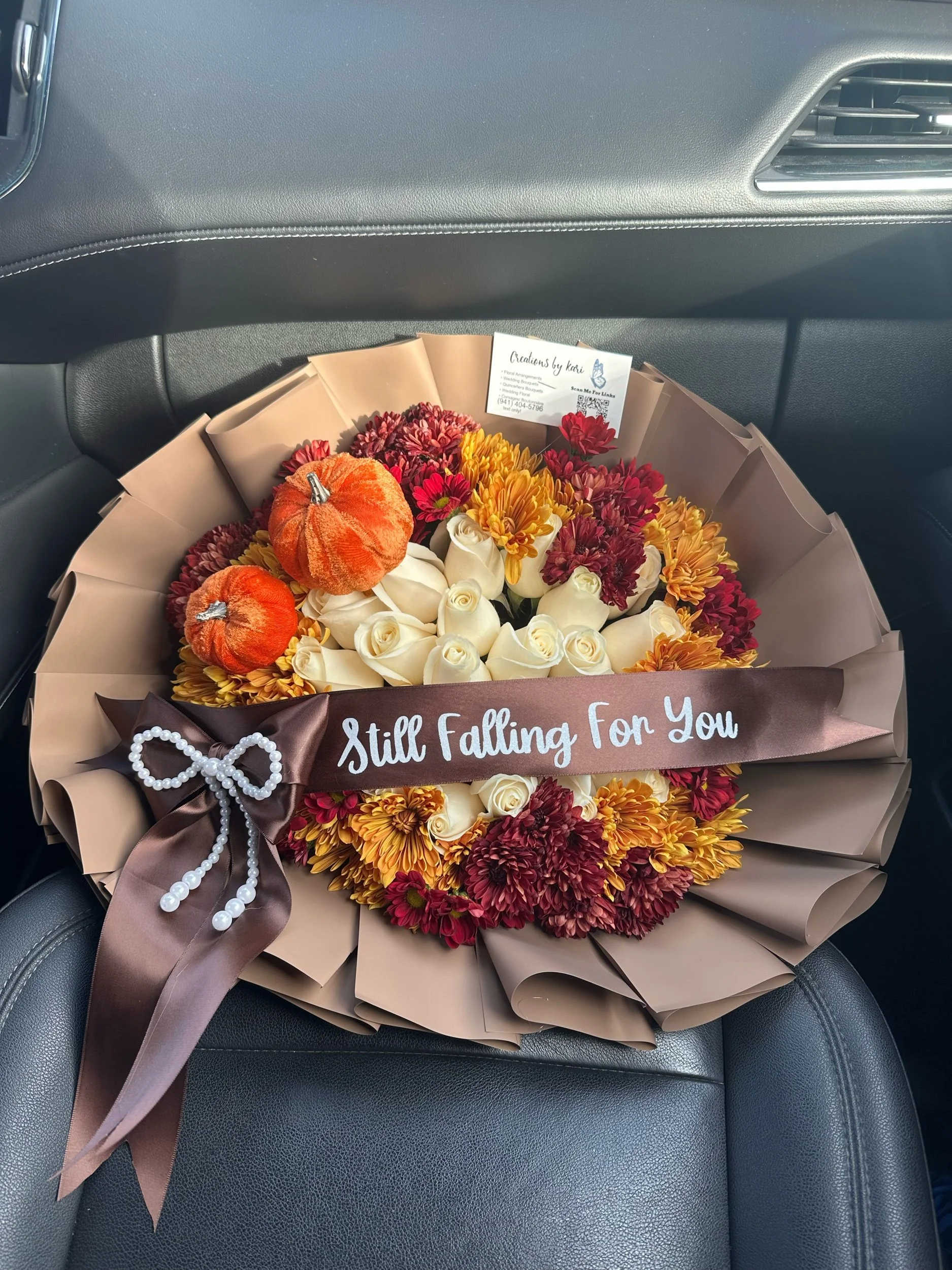 Fall-inspired rose and pom bouquet with decorative pumpkins and a message banner.
