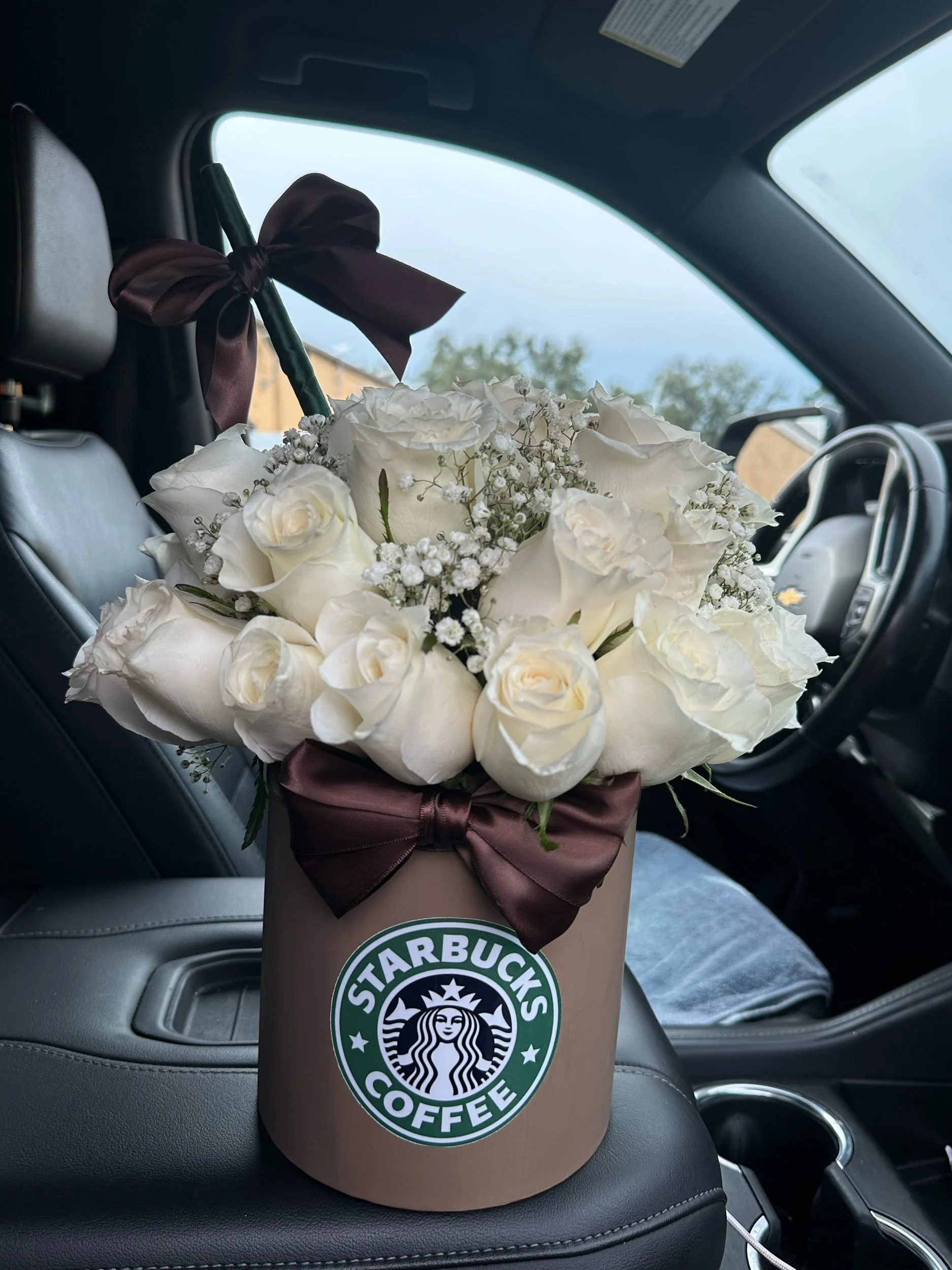 Starbucks-inspired latte box arrangement with white roses and clusters of baby’s breath.