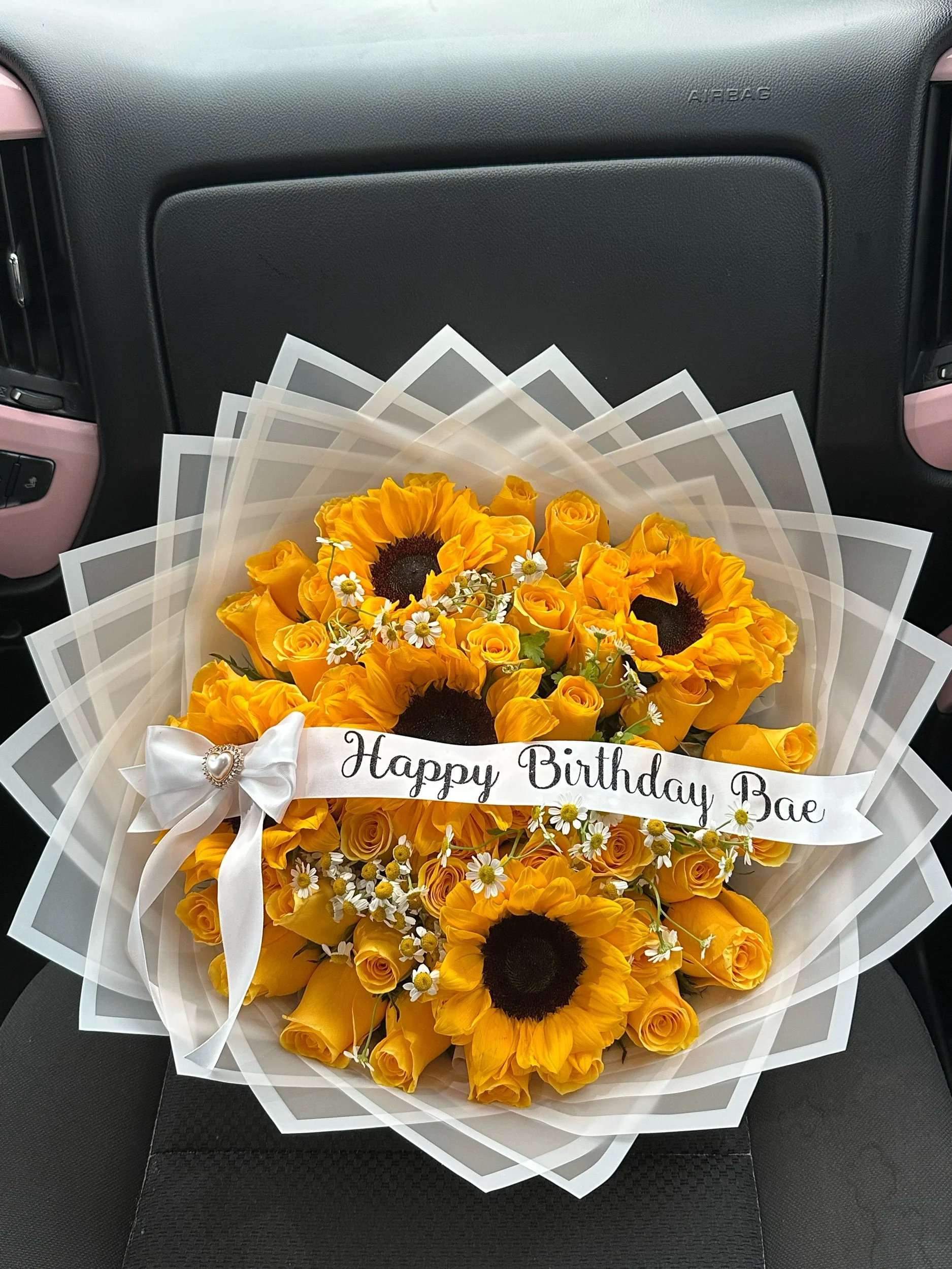 Yellow rose and sunflower bouquet accented with chamomile, a message banner, and white transparent floral wrapping.