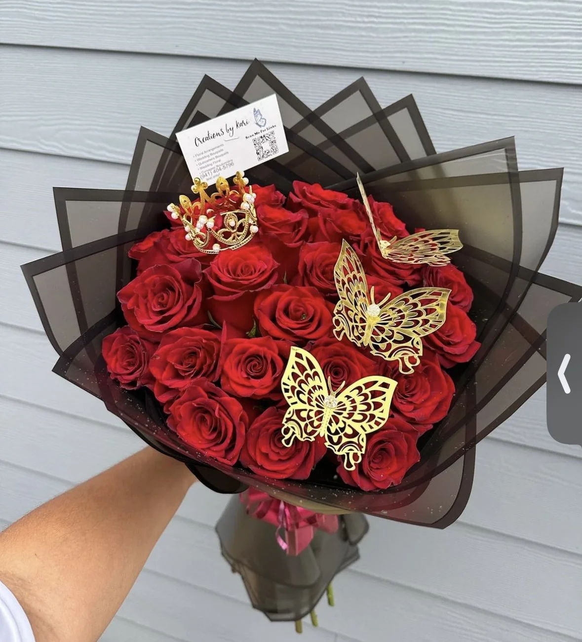 Luxury red rose bouquet with gold butterflies, crown accent, and black wrapping
