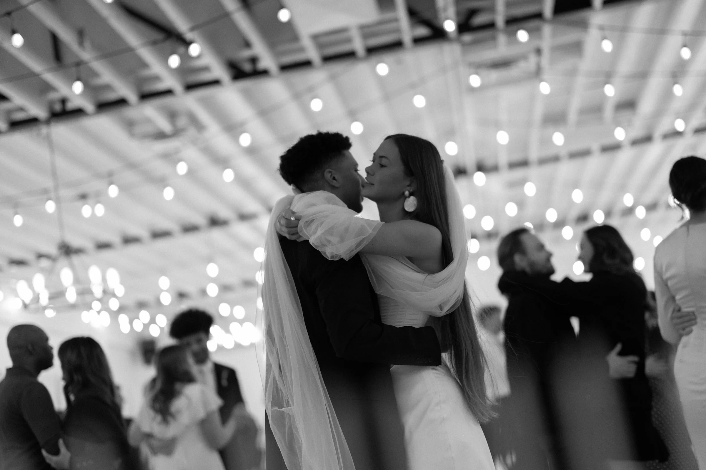 Couple dancing on the dance floor under string lights at The Ivory Hall wedding venue in Provo, Utah