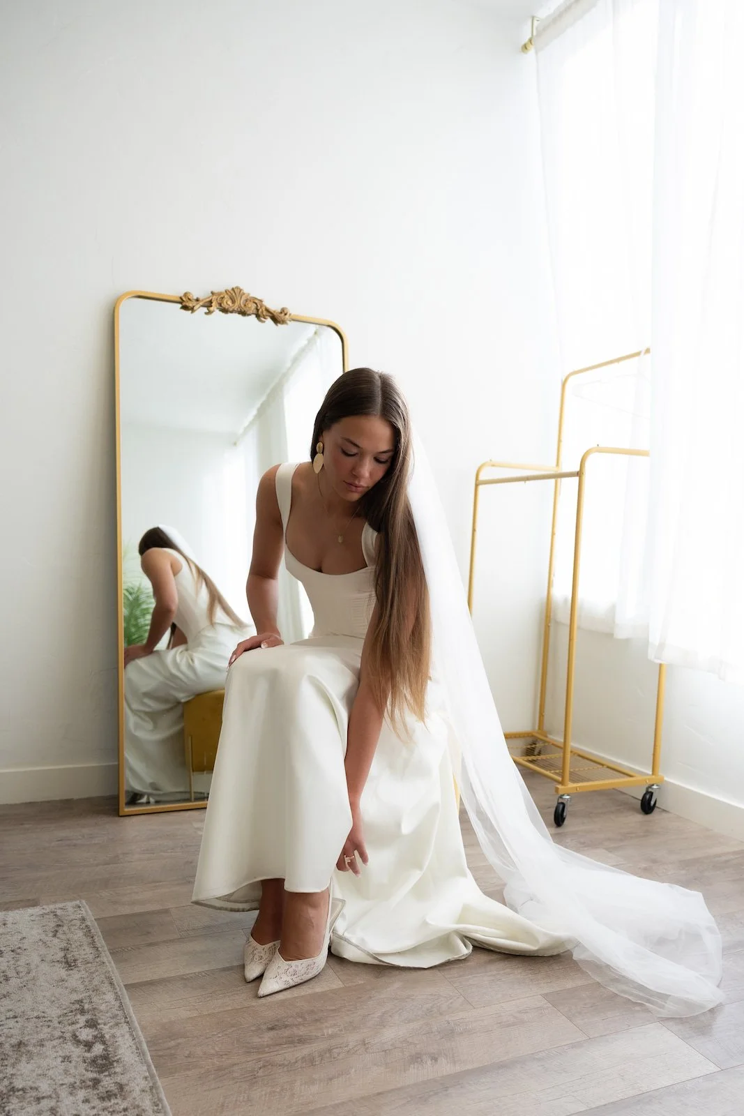bride-putting-on-shoes-bridal-room-mirror-the-ivory-hall-provo-utah.jpg