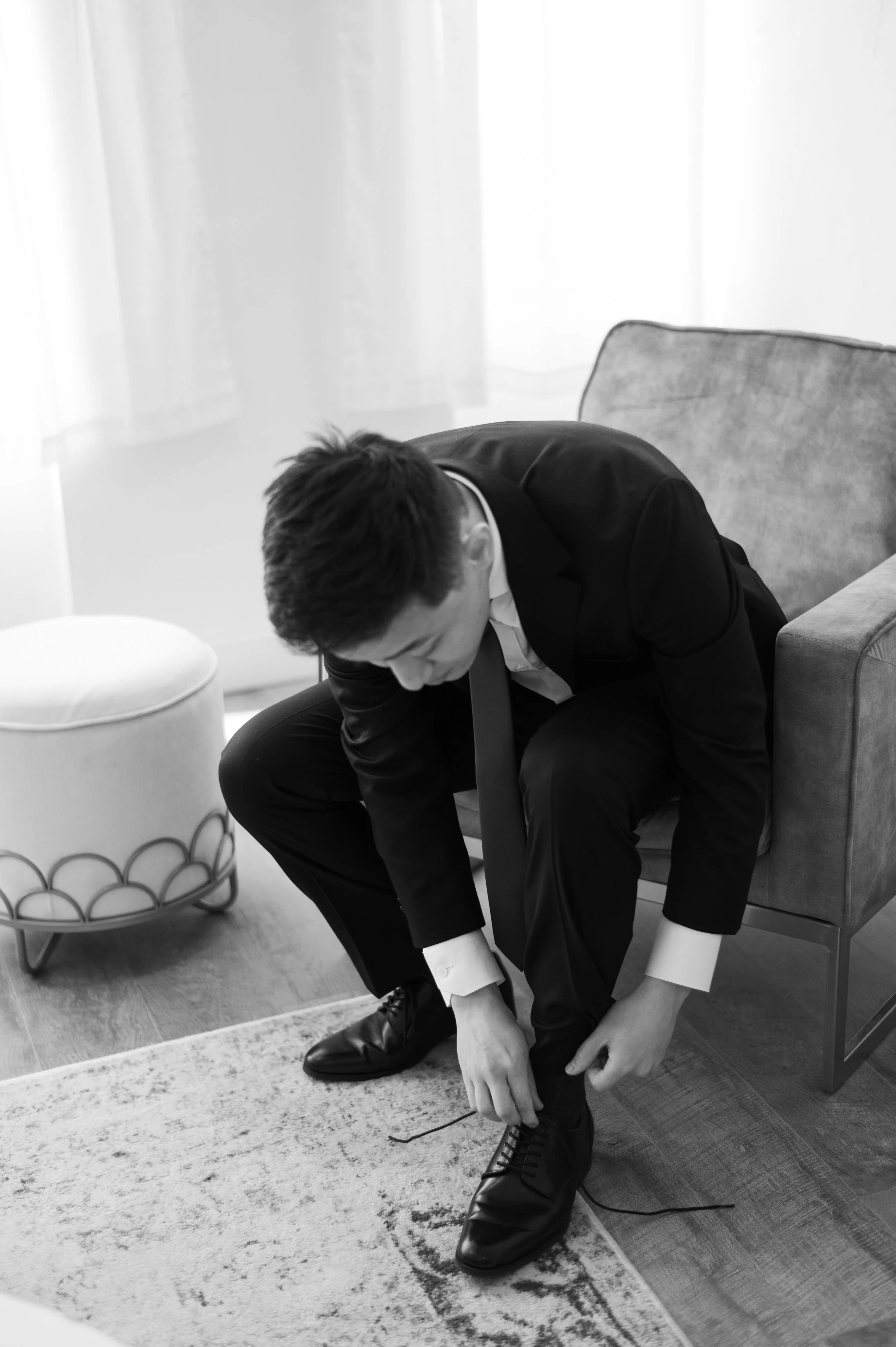 The groom gets ready in The Ivory Hall’s light-filled groom’s suite, adjusting his shoes in a warm and personal moment before the ceremony.