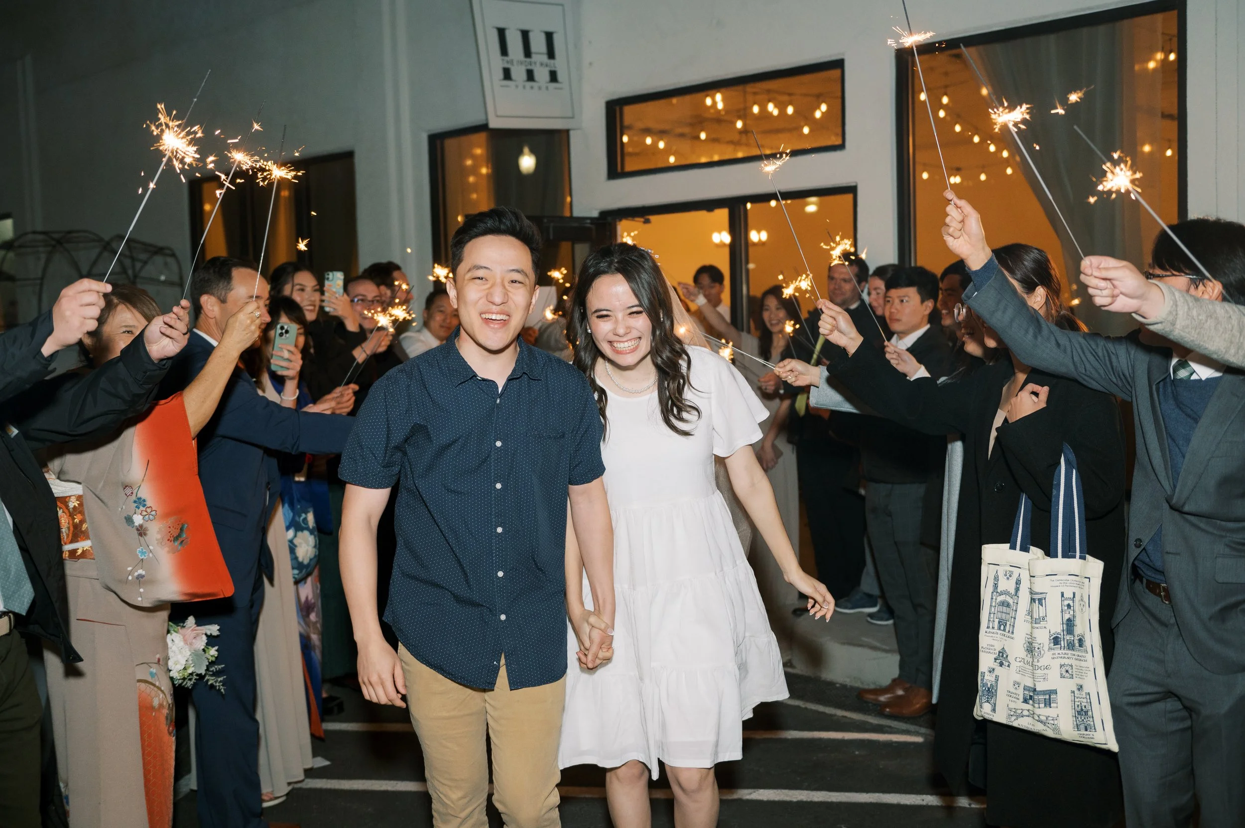 Guests celebrating outside The Ivory Hall, smiling as they exit into the night, capturing the joy and connection felt during a wedding send-off.