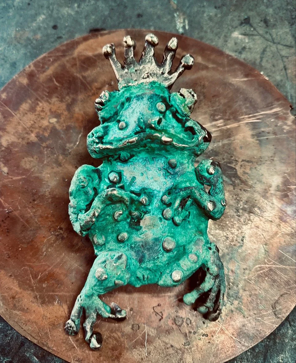 Bronze frog prince sculpture with crown by Melbourne sculptor David Wood of Bent Metal for Howard Dawson Reserve playground.