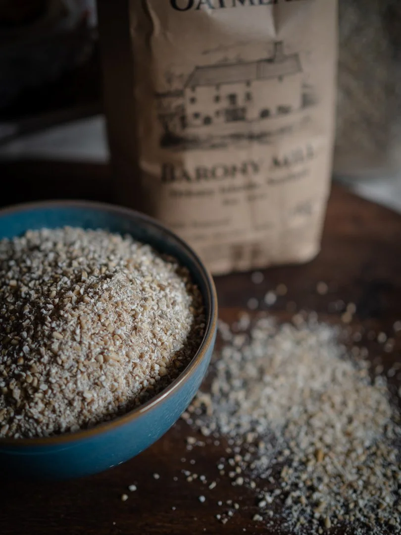 Bowl of Barony Mill medium oatmeal on a wooden tray with the oatmeal bag in the background.