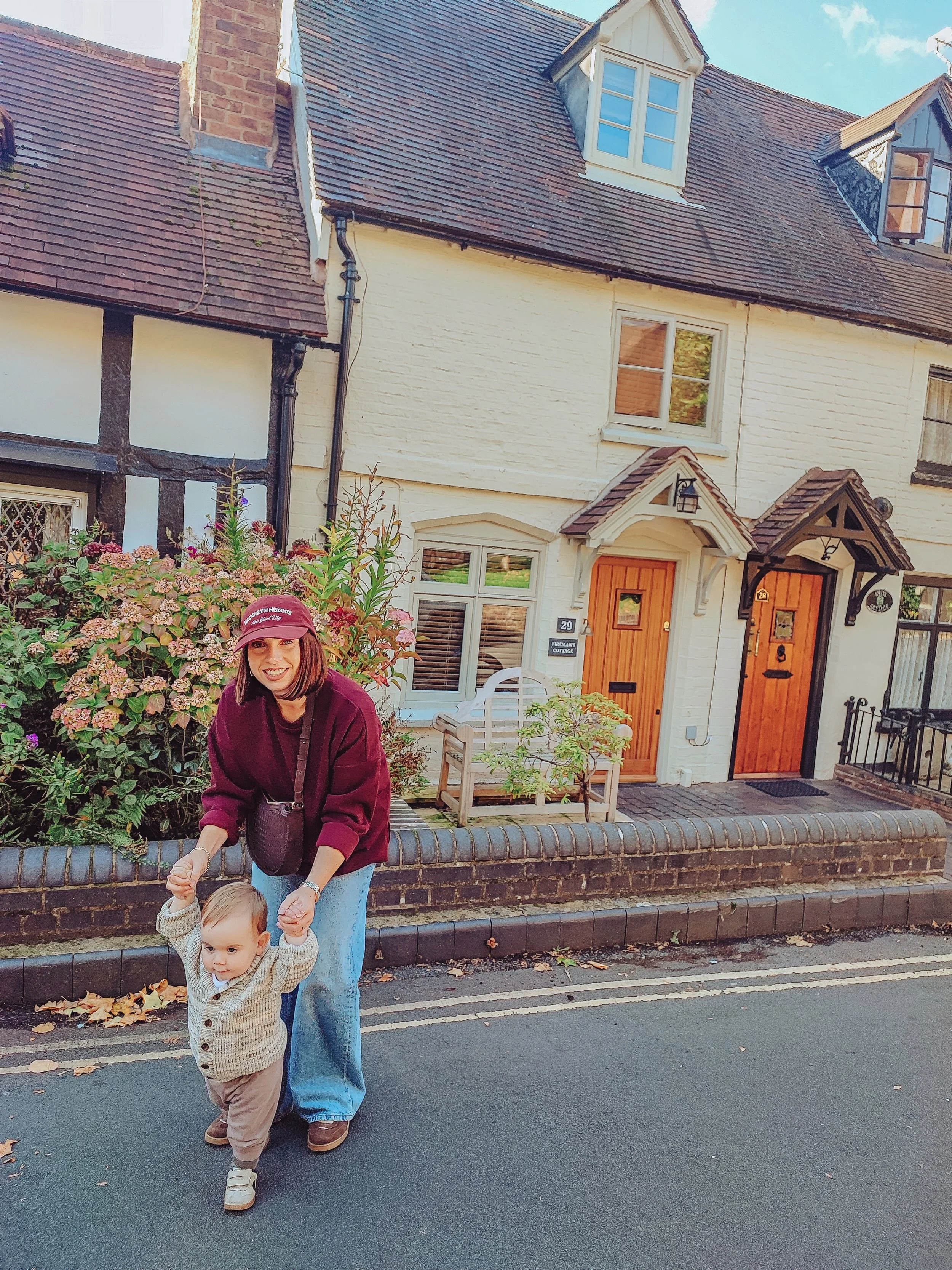 Shelley of Slow Bliss Studio with her son outside an English country cottage, gentle slow motherhood moment