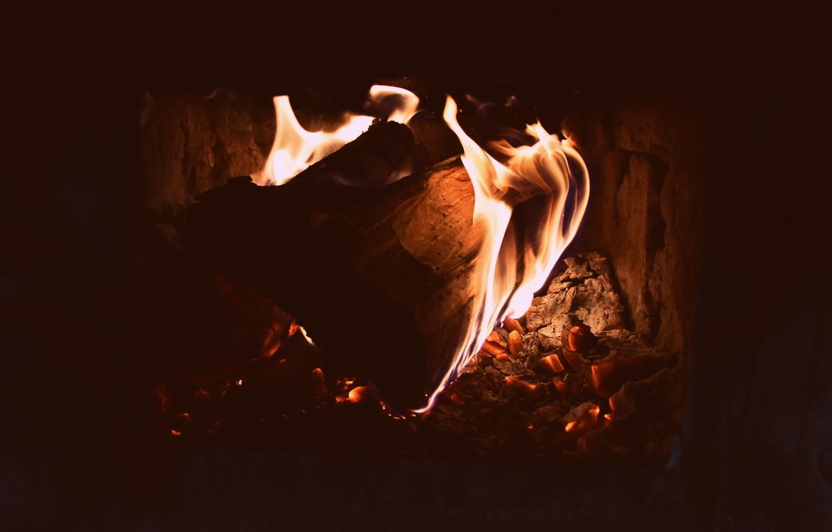 A glowing fire inside a traditional wood-burning stove, evoking warmth, simplicity, and slow living in a rural Romanian home.