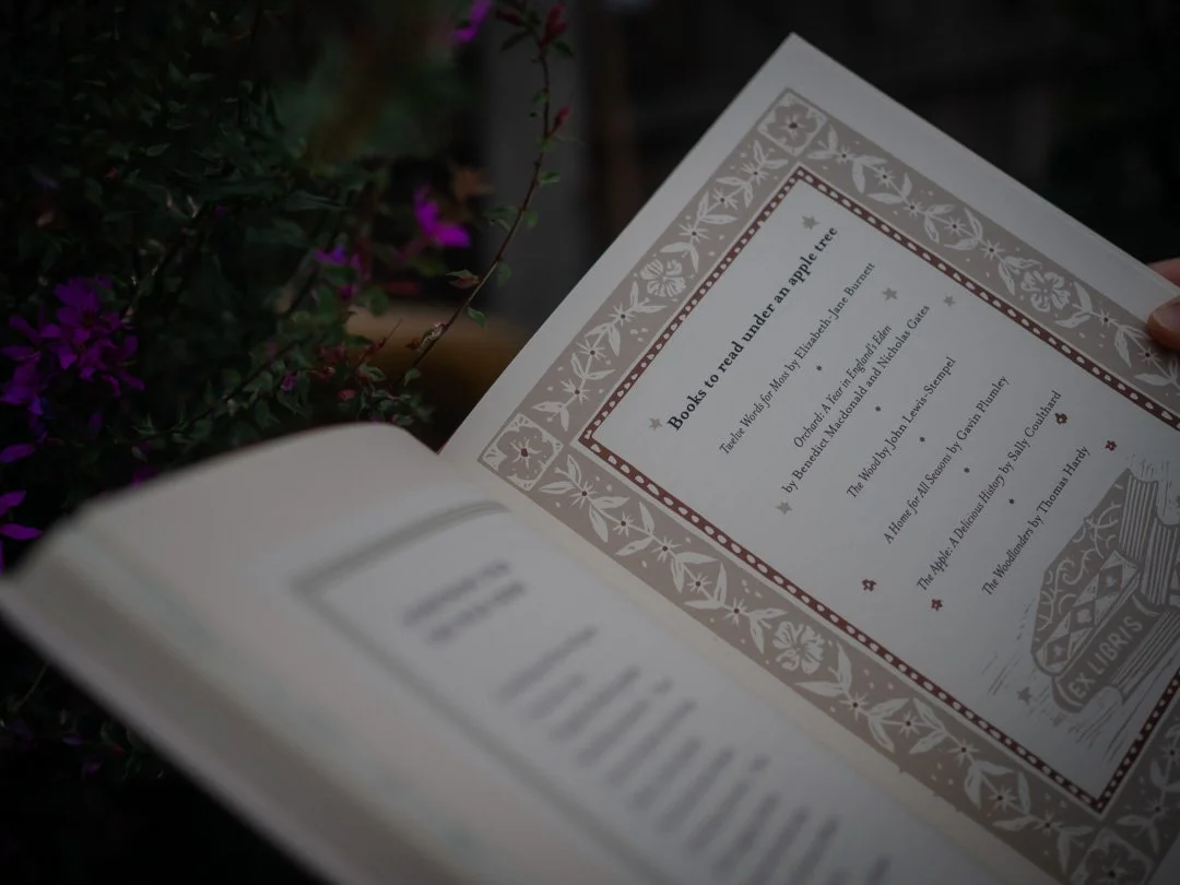 A page from The Country Commonplace Book by Miranda Mills listing books to read under an apple tree.