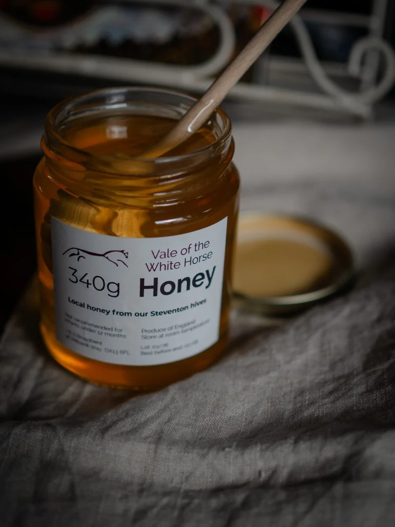 Jar of honey, a traditional natural sweetener in a simple store cupboard.
