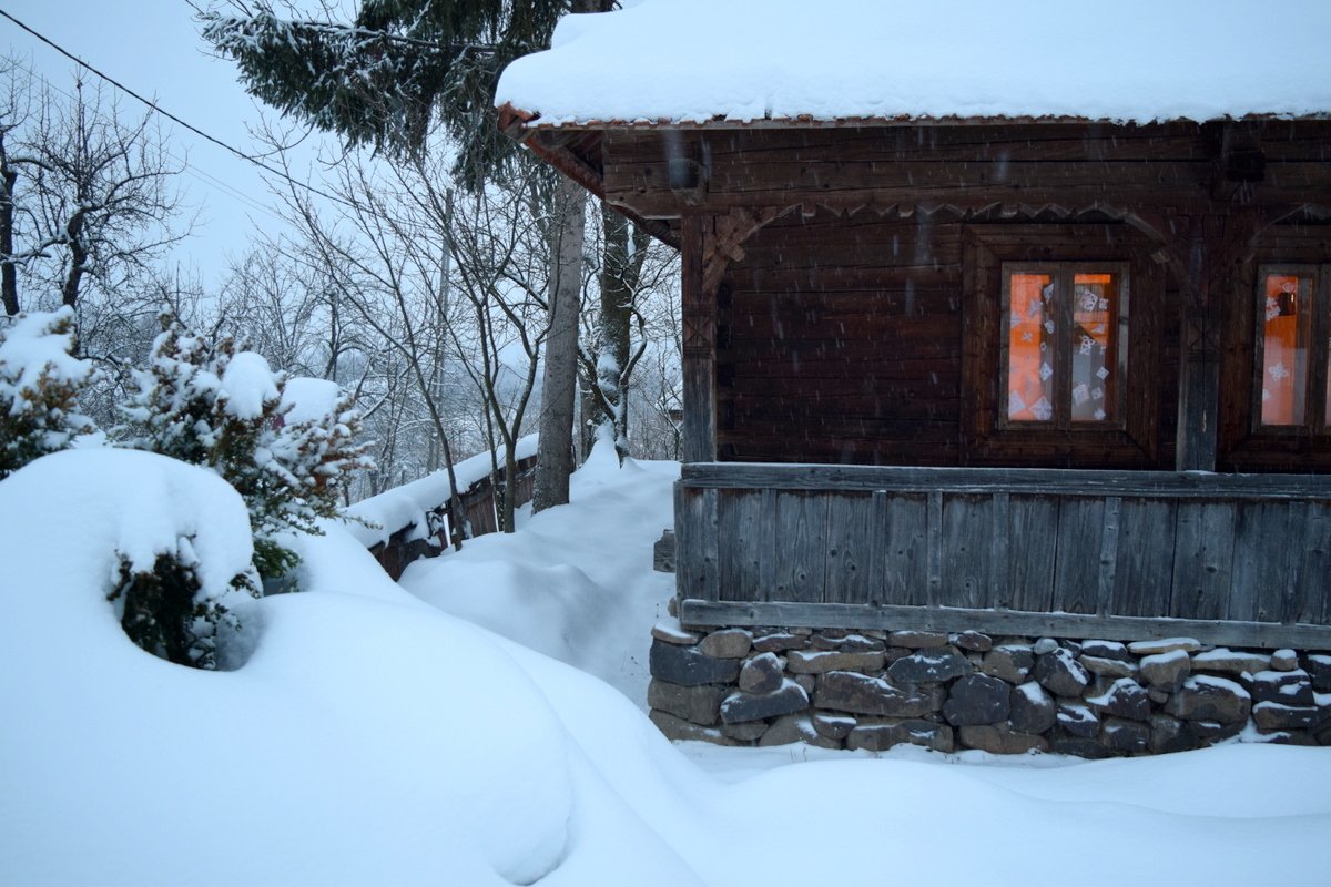 A snow-covered home in the mountains of northern Romania, illustrating a quiet, seasonal rhythm of life in winter.