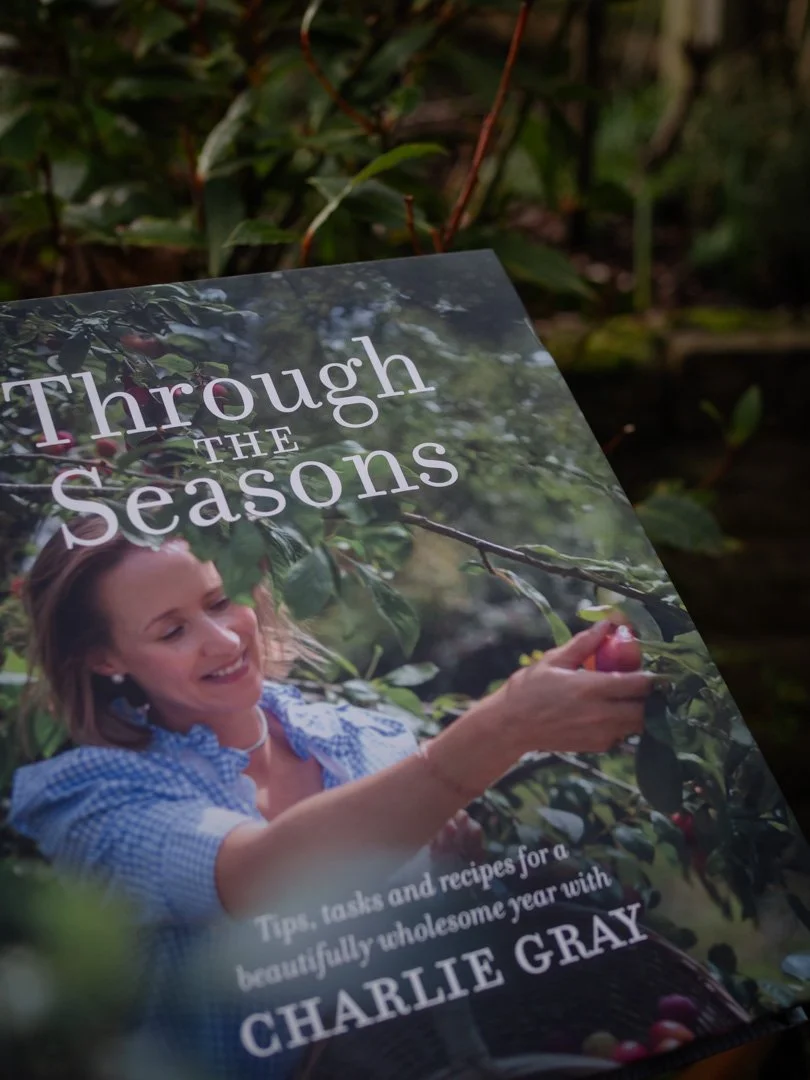 Front cover of Through the Seasons by Charlie Gray, photographed outdoors with a bay tree in the background.