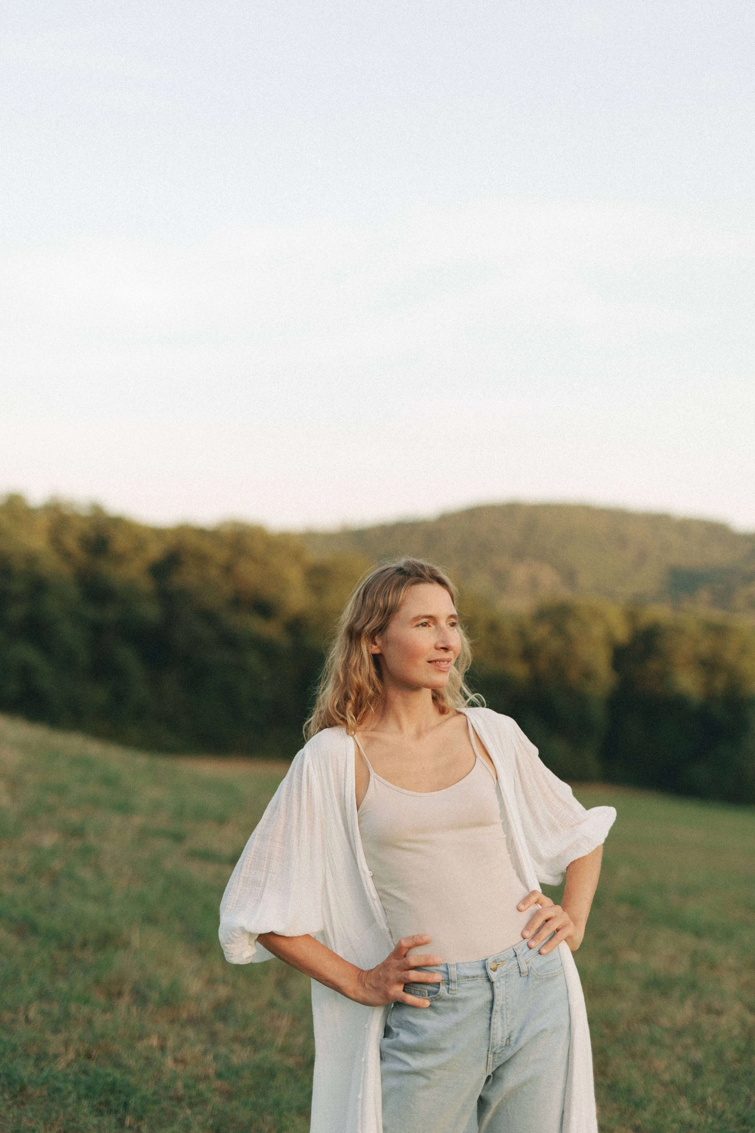 Verena Borell standing outdoors among the hills and mountains of Austria, embracing a slower and more seasonal life.