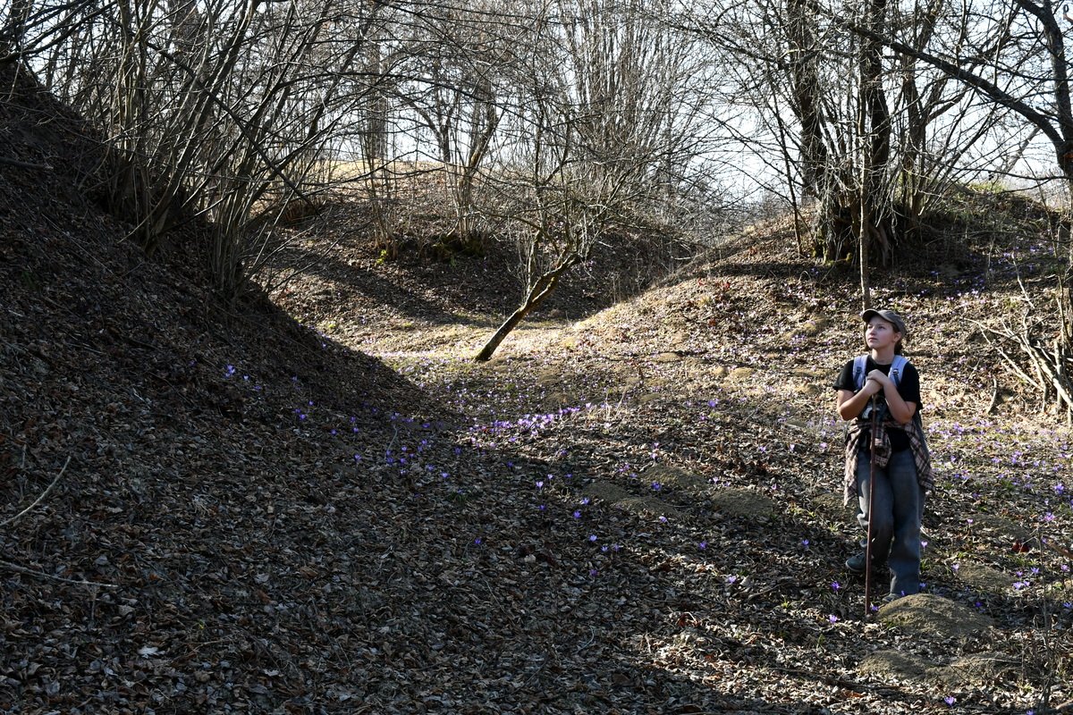 Csermely Szilvia standing in a quiet forest in the Romanian countryside, reflecting a life rooted in nature and slow living