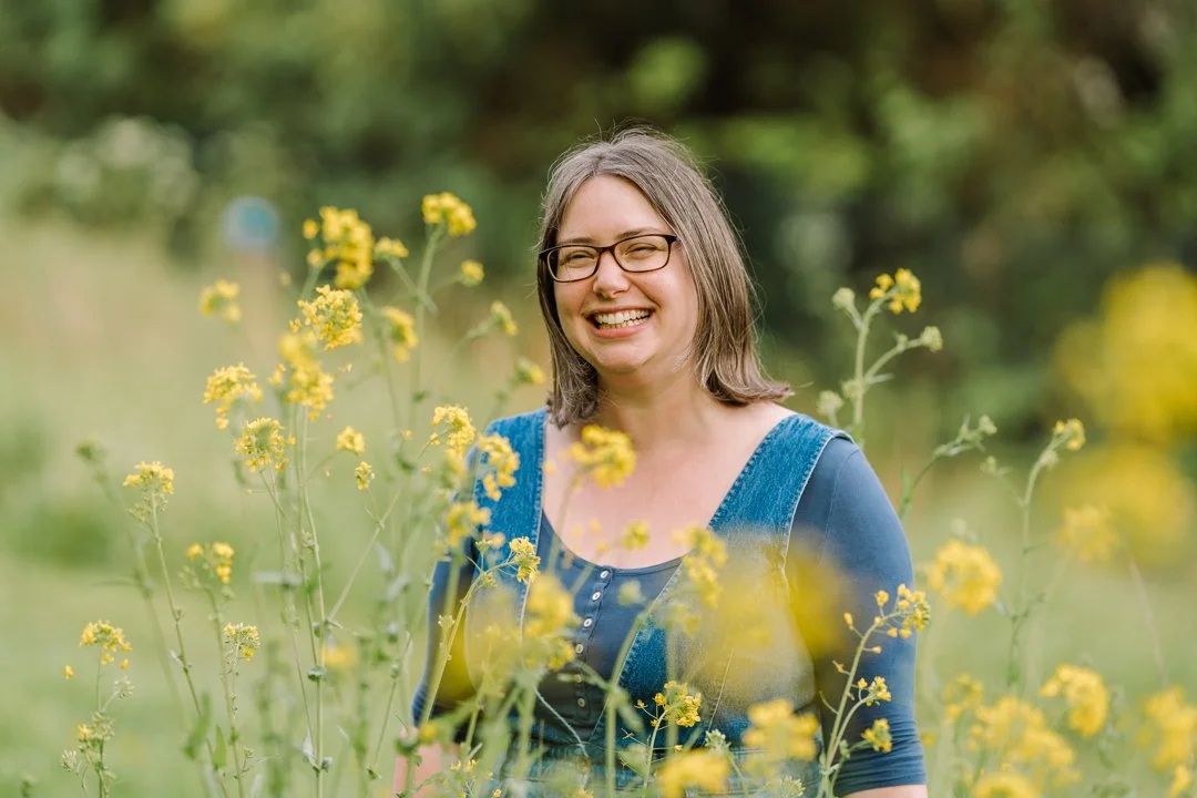 Portrait of creative guide Rhiannon Adler smiling in a grassy meadow.