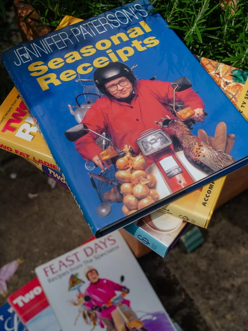 Jennifer Paterson's Seasonal Recipes cookbook displayed above a stack of Two Fat Ladies cookbooks celebrating seasonal cooking.