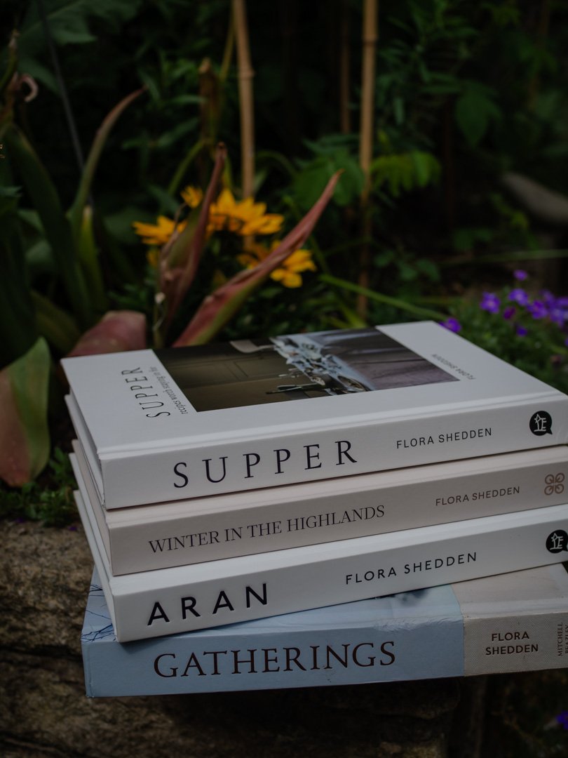 A stack of cookbooks by Flora Shedden featuring seasonal baking, Scottish food culture, and simple home cooking.