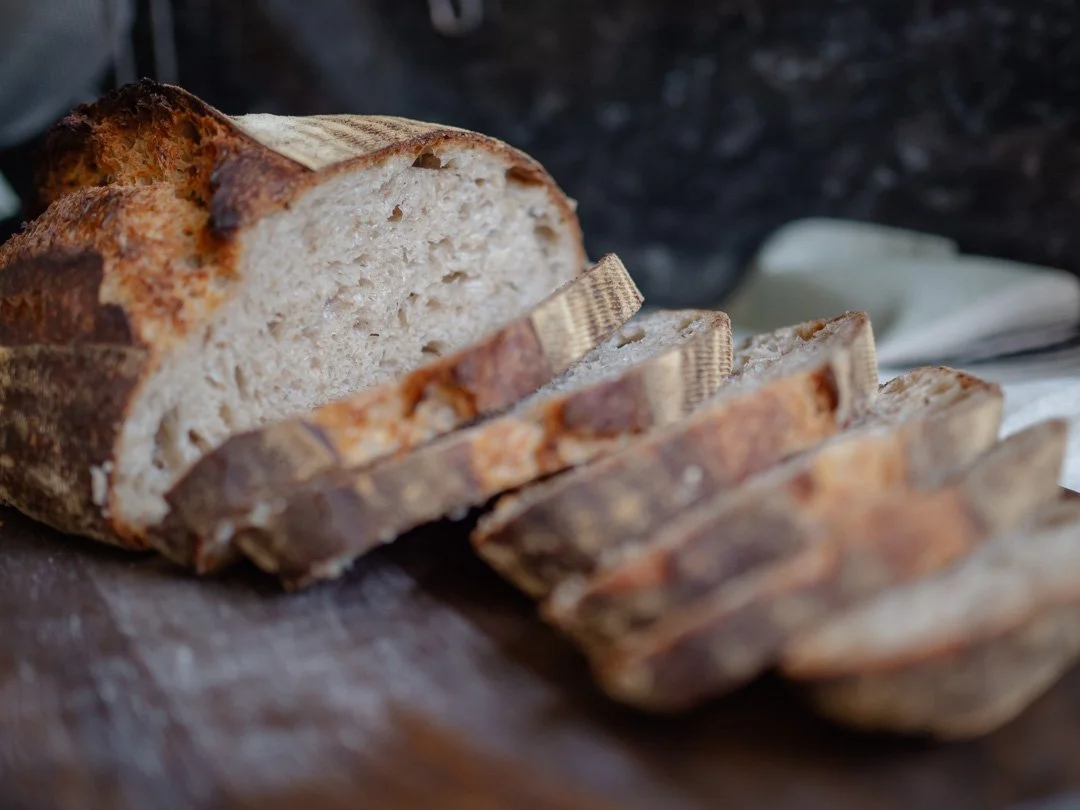 Freshly sliced homemade sourdough bread on a wooden surface.