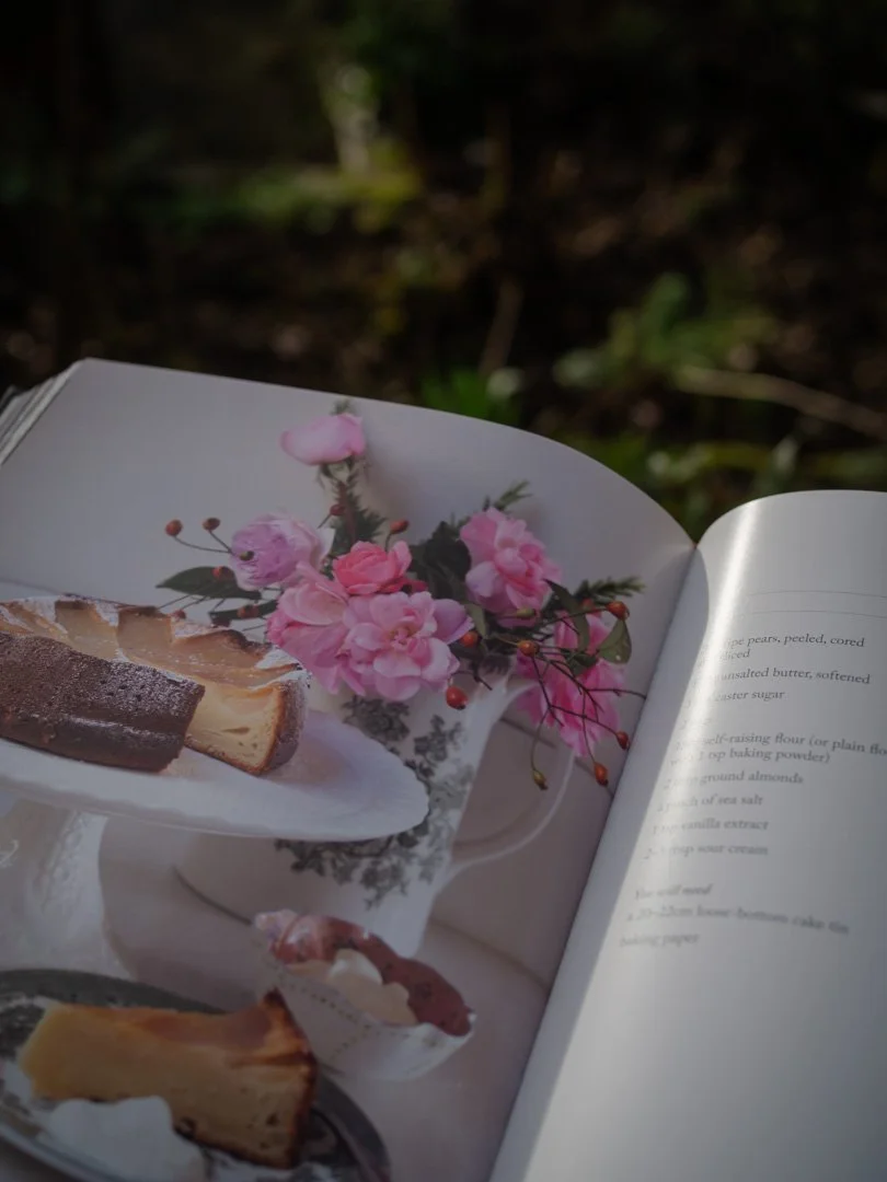 Illustration of pear cake in Through the Seasons by Charlie Gray, with summer flowers in the background.