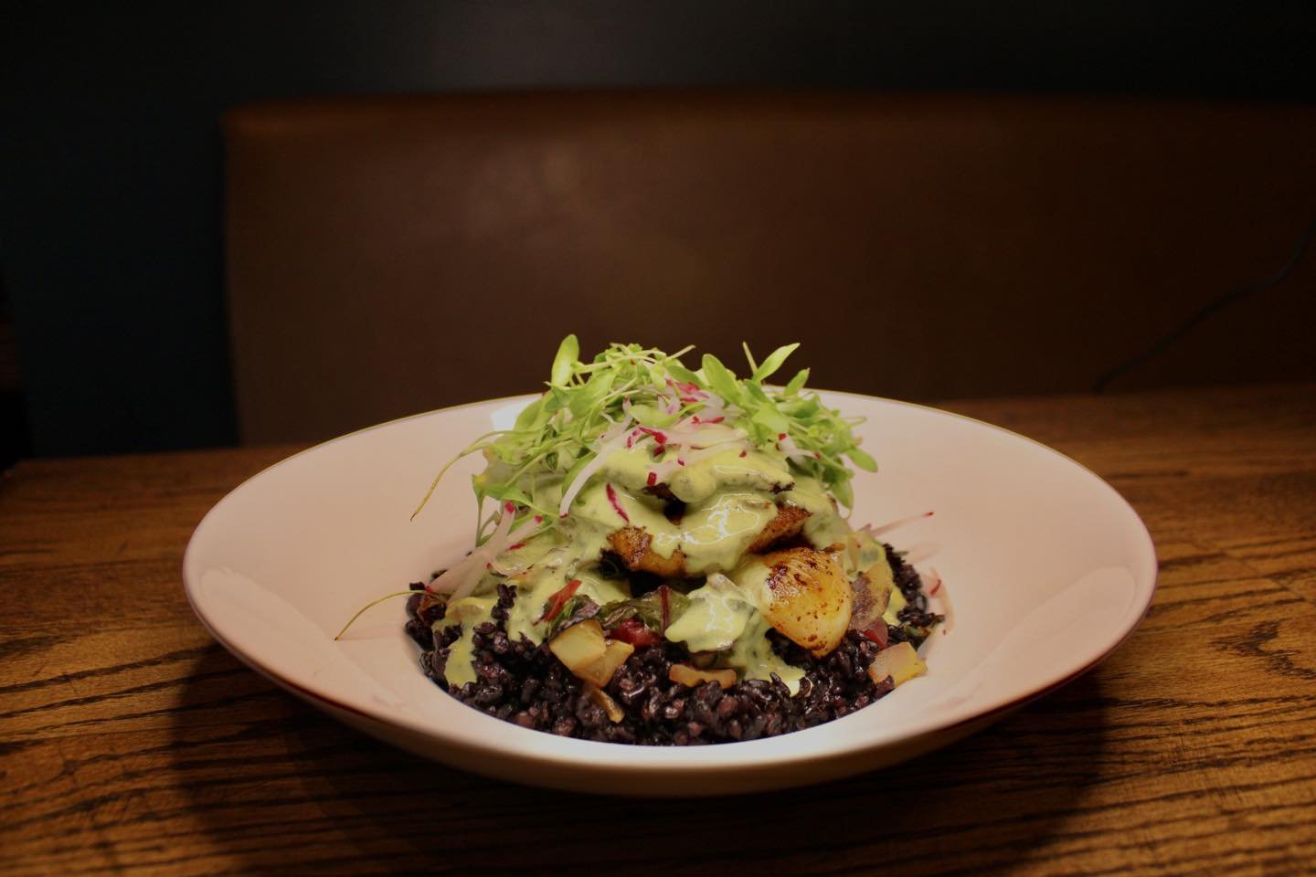 Calling all Bass lovers! Our Blackened Striped Bass has gotten a few upgrades, made with black rice, green tomato, roasted onions, Swiss chard, pickled red onion with a cilantro-lime butter sauce, fresh radish and micro cilantro.