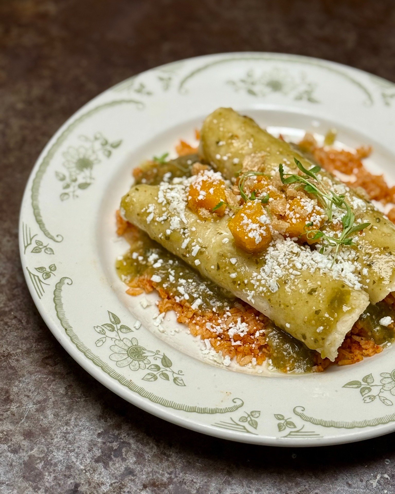 Pork carnitas enchiladas with house-made tortillas, Carolina gold red rice, tomatillo salsa, fall squash, queso fresco, chicharr&oacute;nes, and micro cilantro. 
Bold flavors, made from scratch. ✨

Reservations can be made by following the link in ou