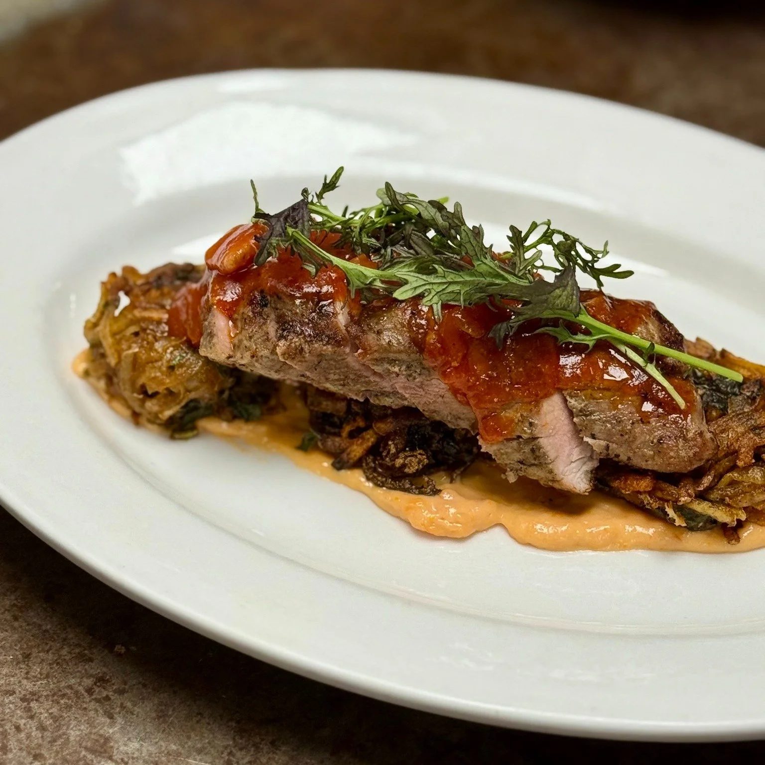 Savory &amp; Sophisticated 🥩🌿
Rosemary-garlic marinated pork tenderloin served with mustard greens hash browns, sun-dried tomato aioli, bacon-onion-tomato jam, and curly baby kale&mdash;rich flavors thoughtfully composed.

Reservations can be made 