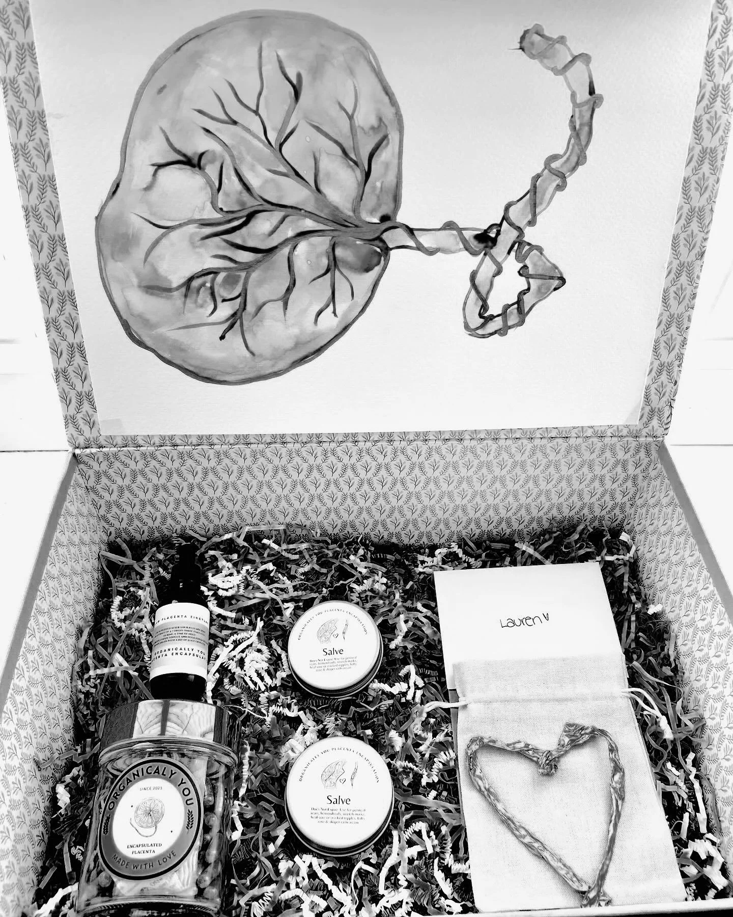 A gift box containing skincare products and a card with the name Lauren V, with tissue paper and a heart-shaped decoration inside.