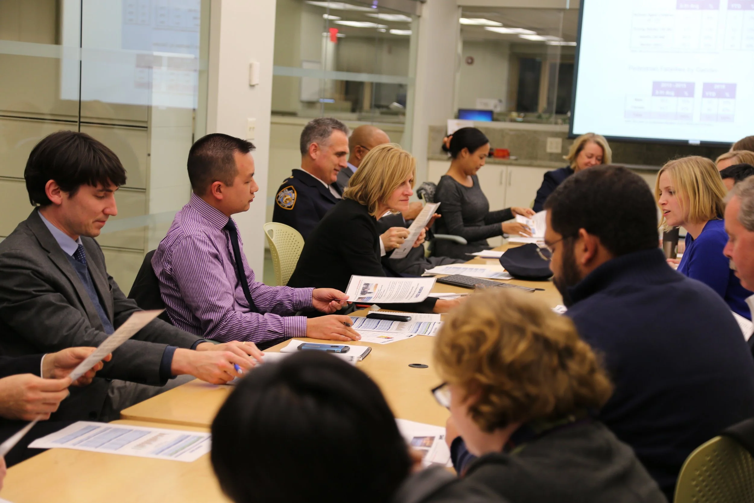 A large group of people holding a meeting at a table