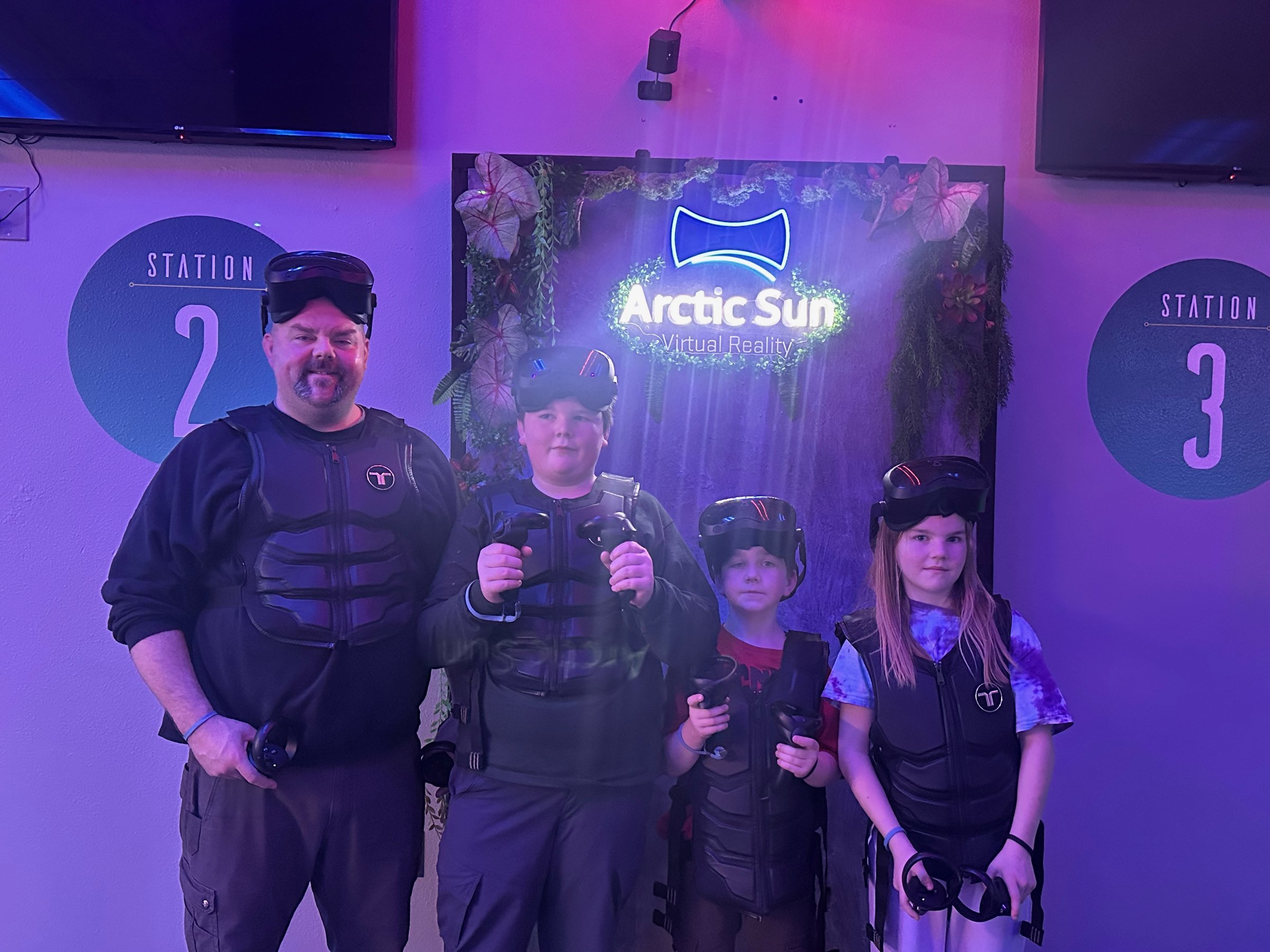 A family at the logo wall, 2025