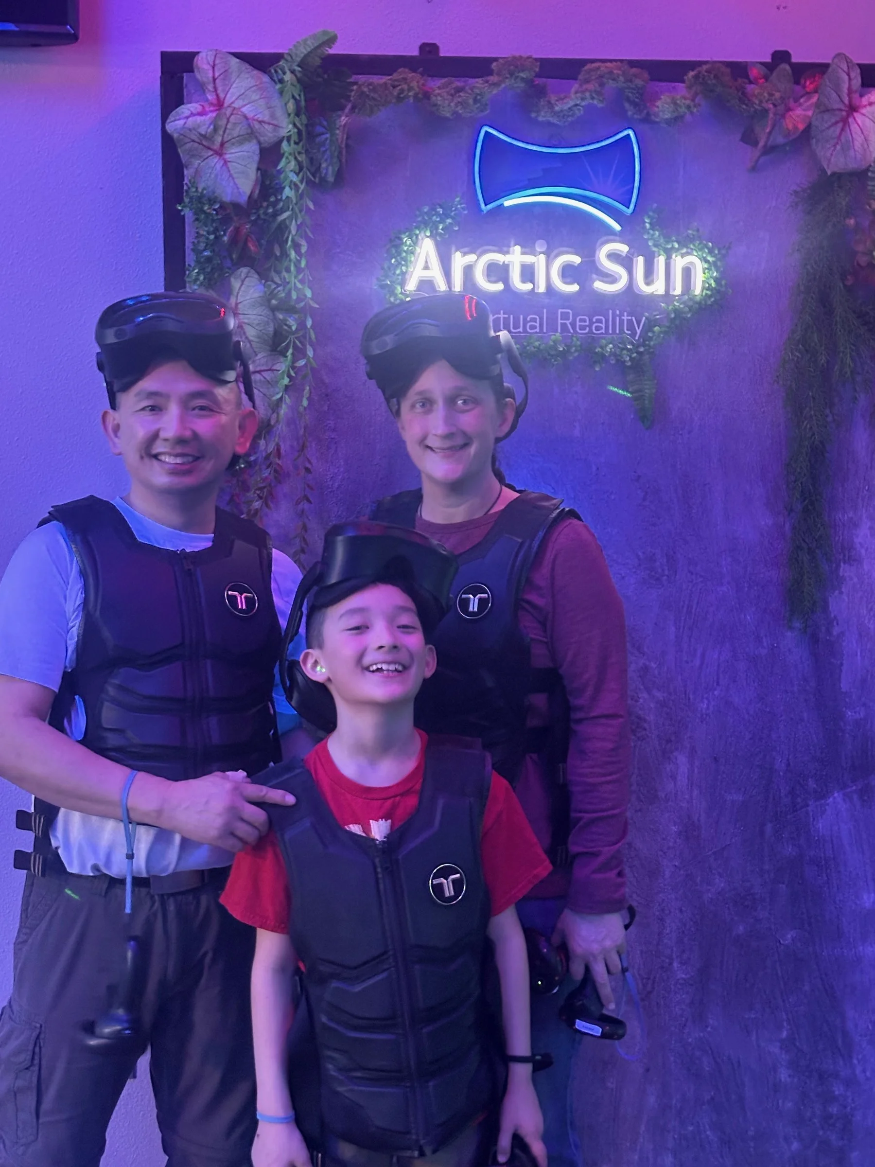 A family at the logo wall, 2025