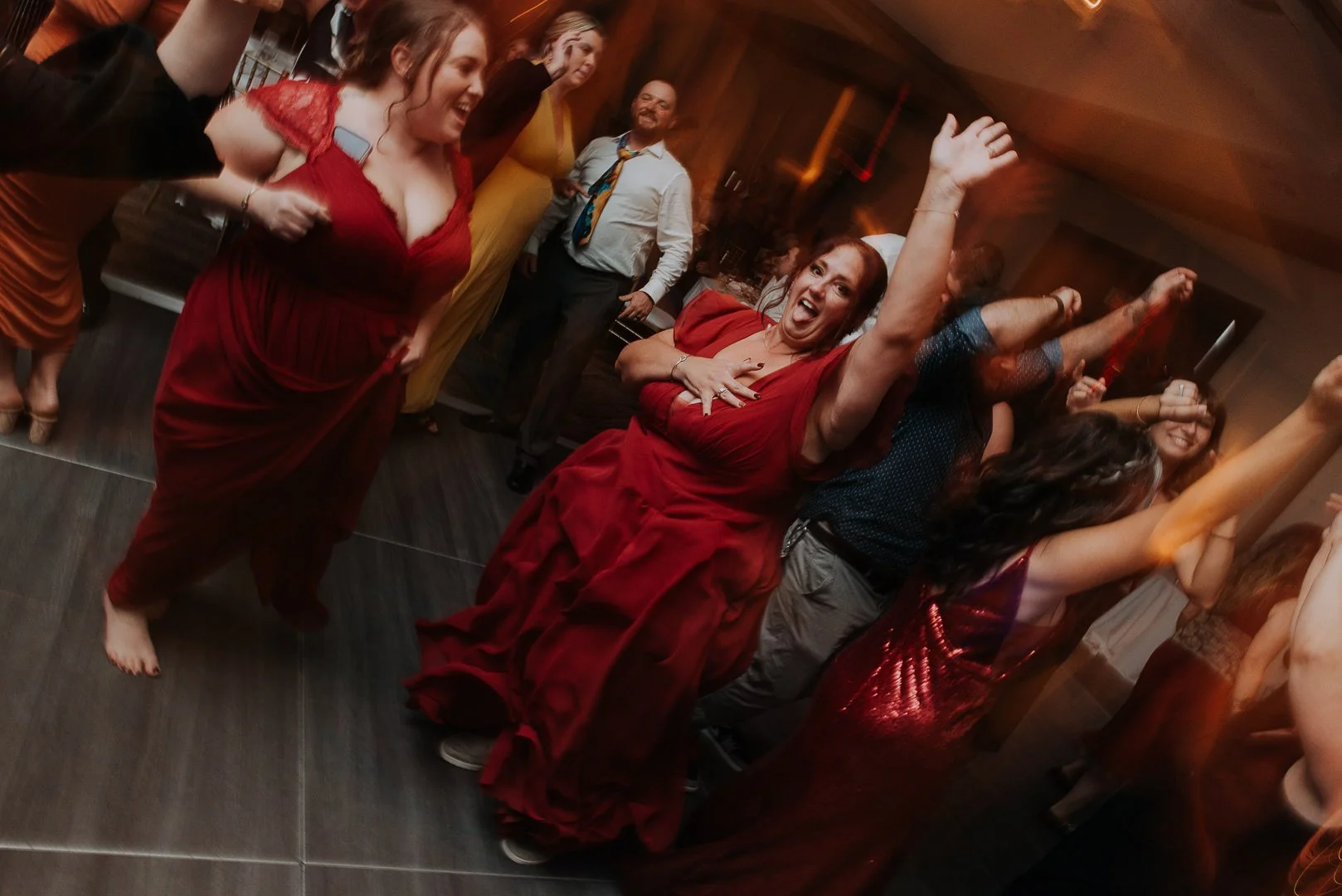 People dancing and celebrating at a lively indoor party or event, with joyful expressions and energetic poses.