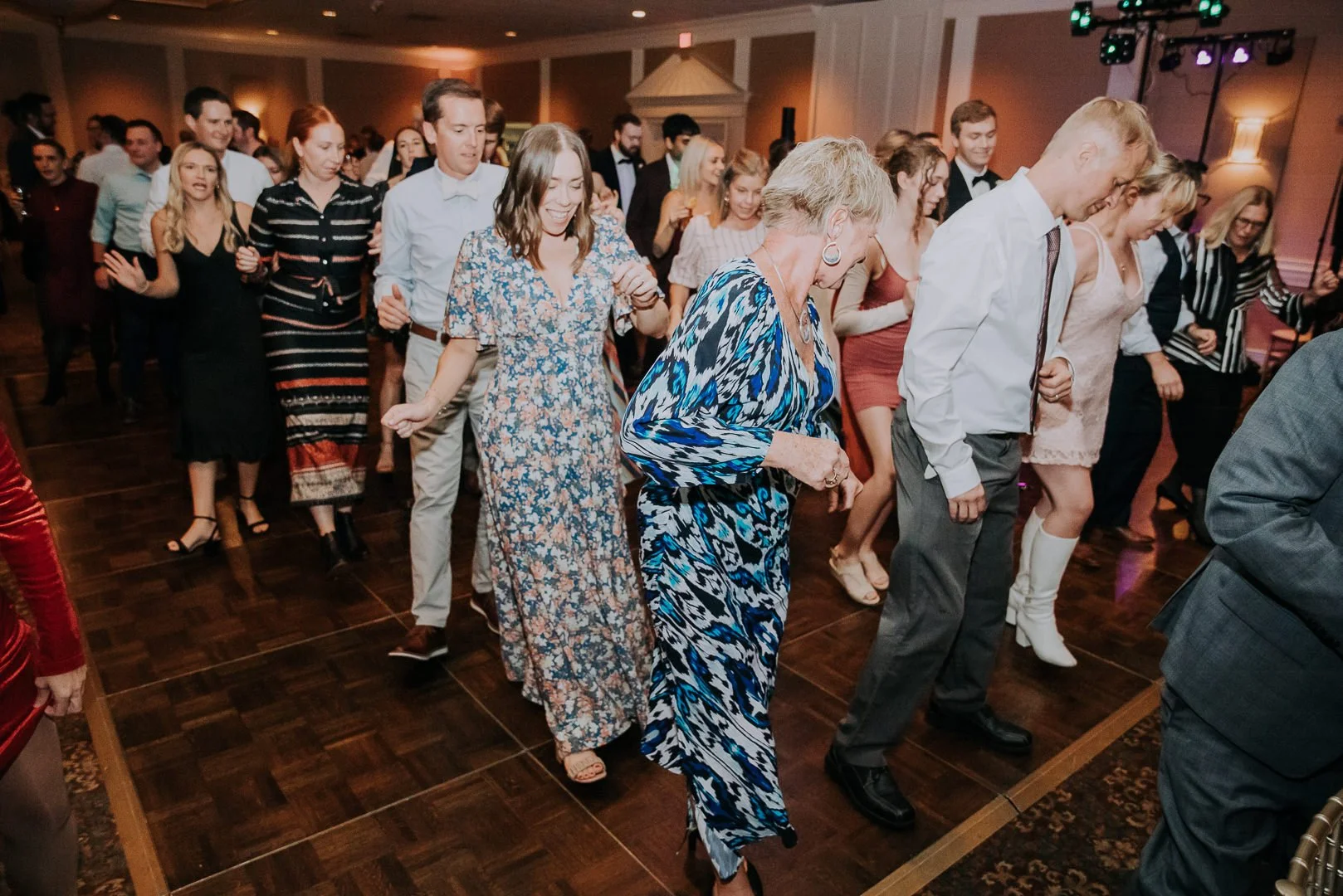 Group of people dancing at a party or celebration indoors.