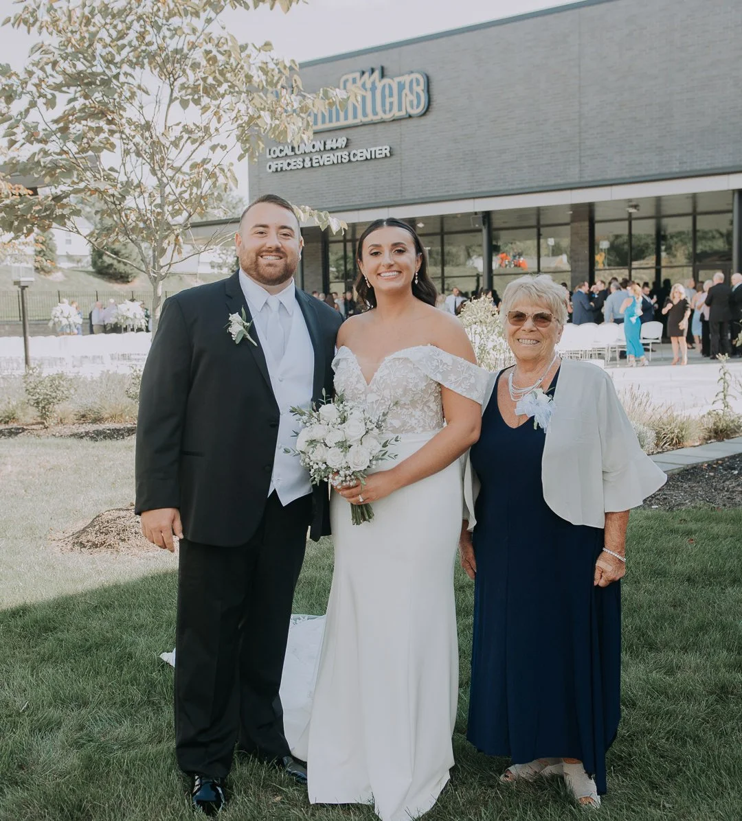 Bride and groom with an older woman at a wedding outside the local union event center