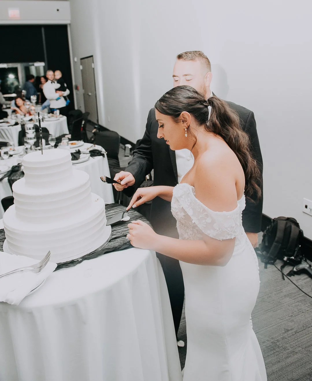 Bride and groom cutting a wedding cake together at their wedding reception.