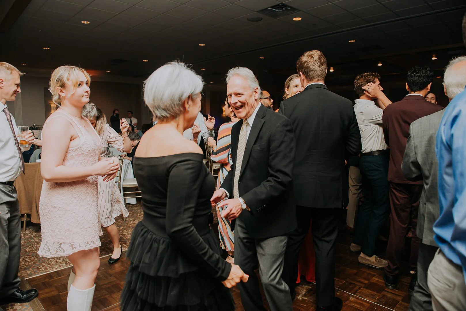 People dancing and socializing at a wedding reception.