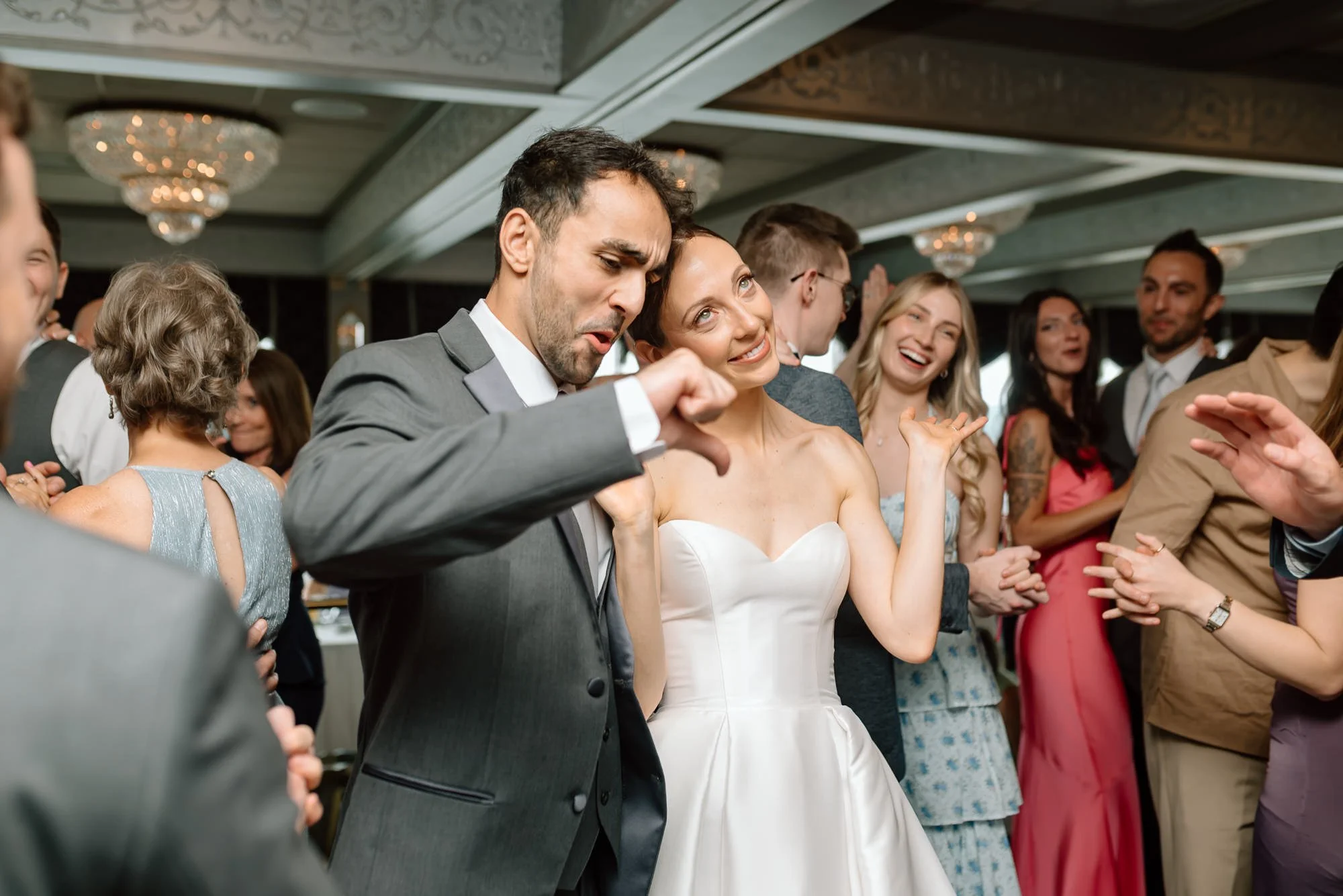 People dancing at a celebration or wedding reception, enjoying the moment.