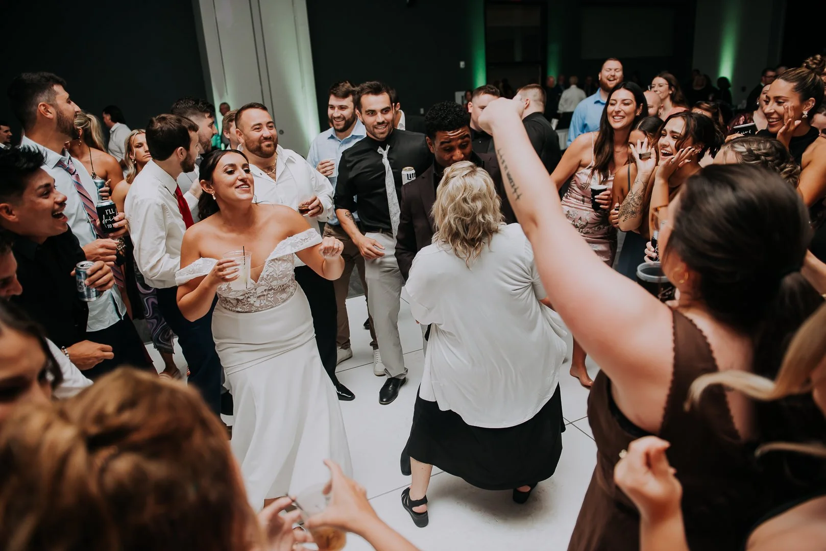 A wedding reception with guests dancing and celebrating.