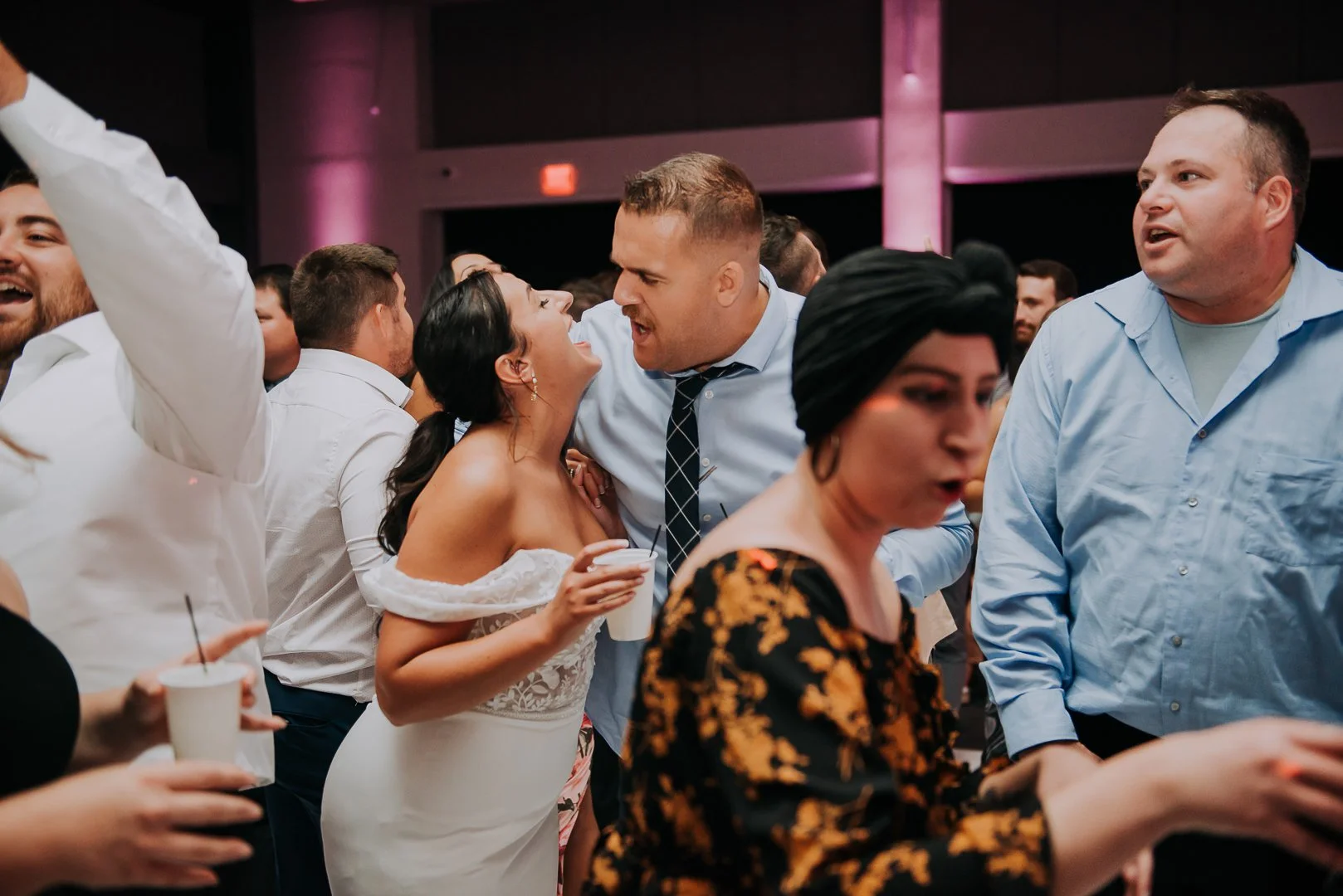 People dancing and socializing at a lively event or party in an indoor venue.