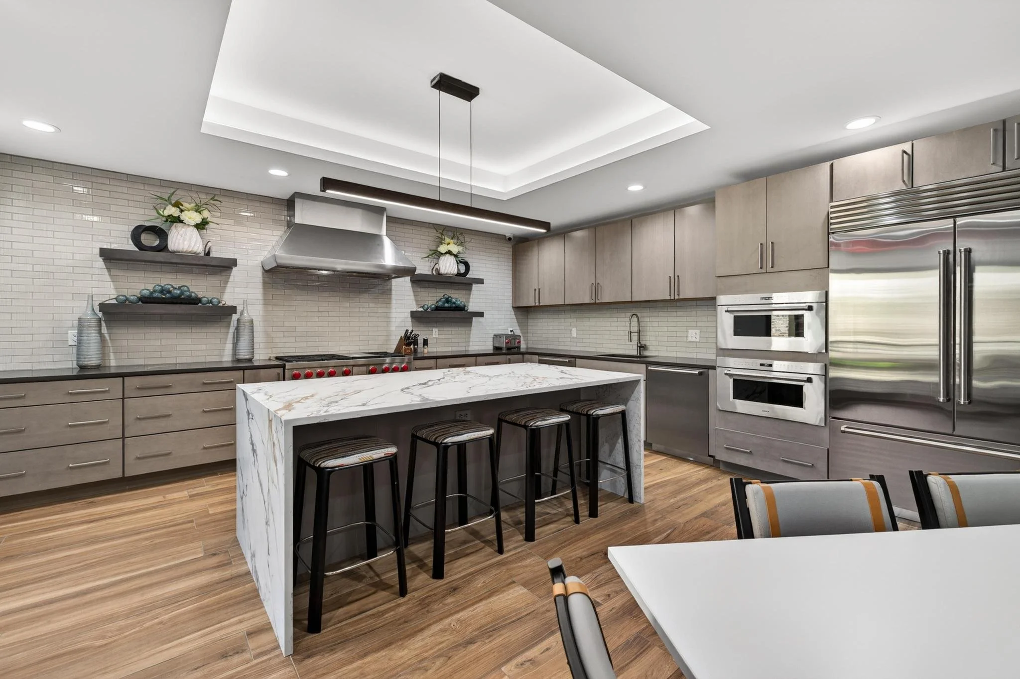 Large Modern kitchen, marble waterfall counter with gray cabinets and large fridge