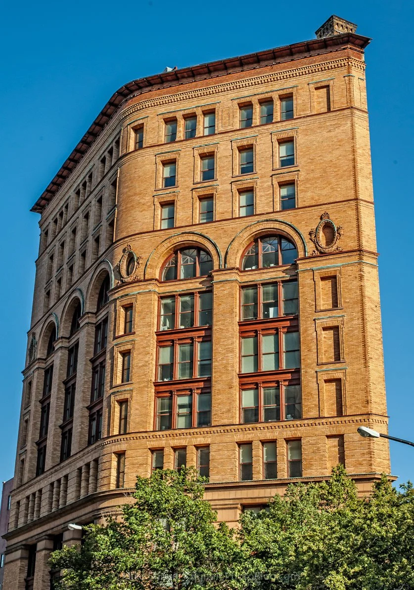 tan brick building with large, arched windows and impressive architecture