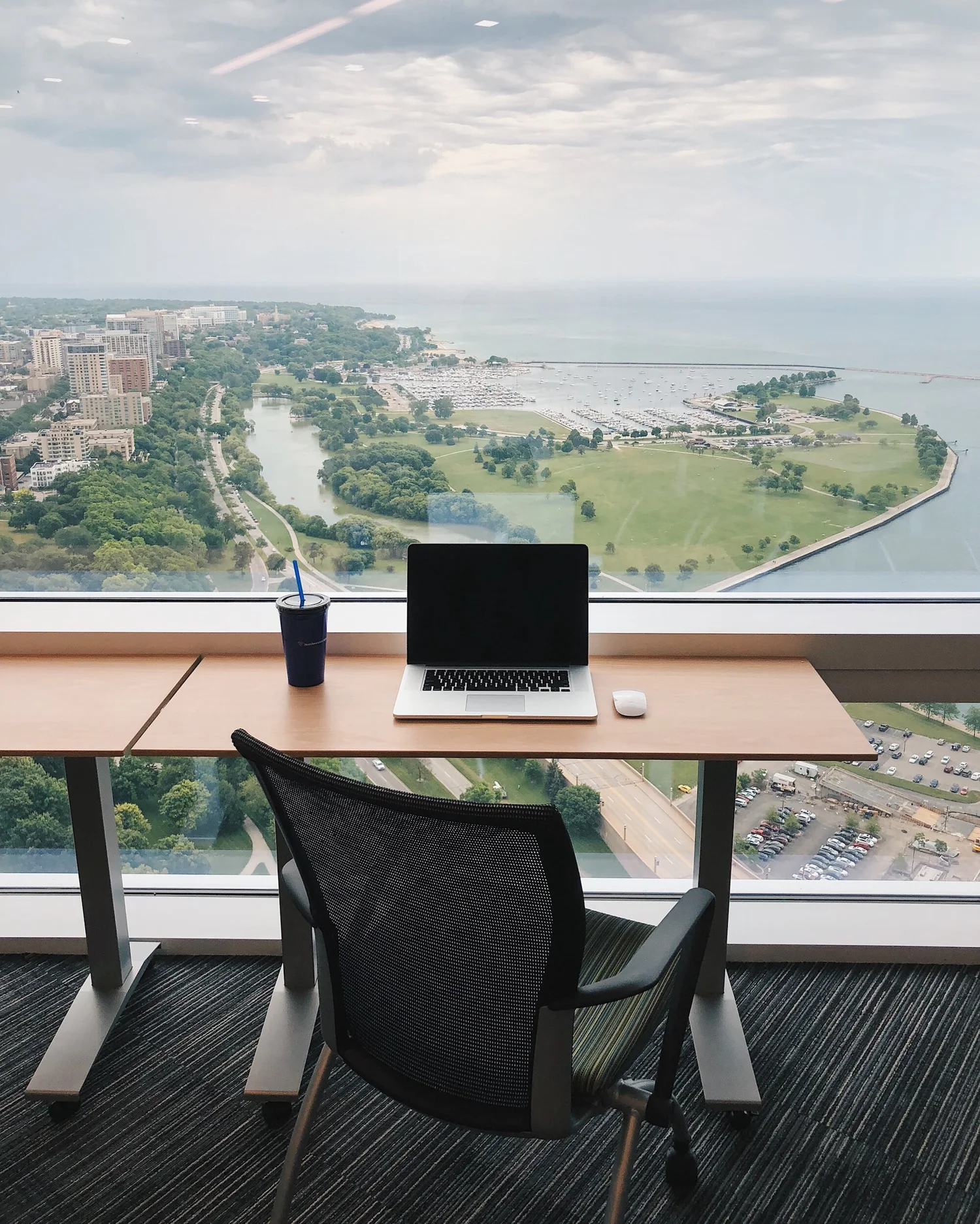 A tidy desk with a laptop overlooking a city view