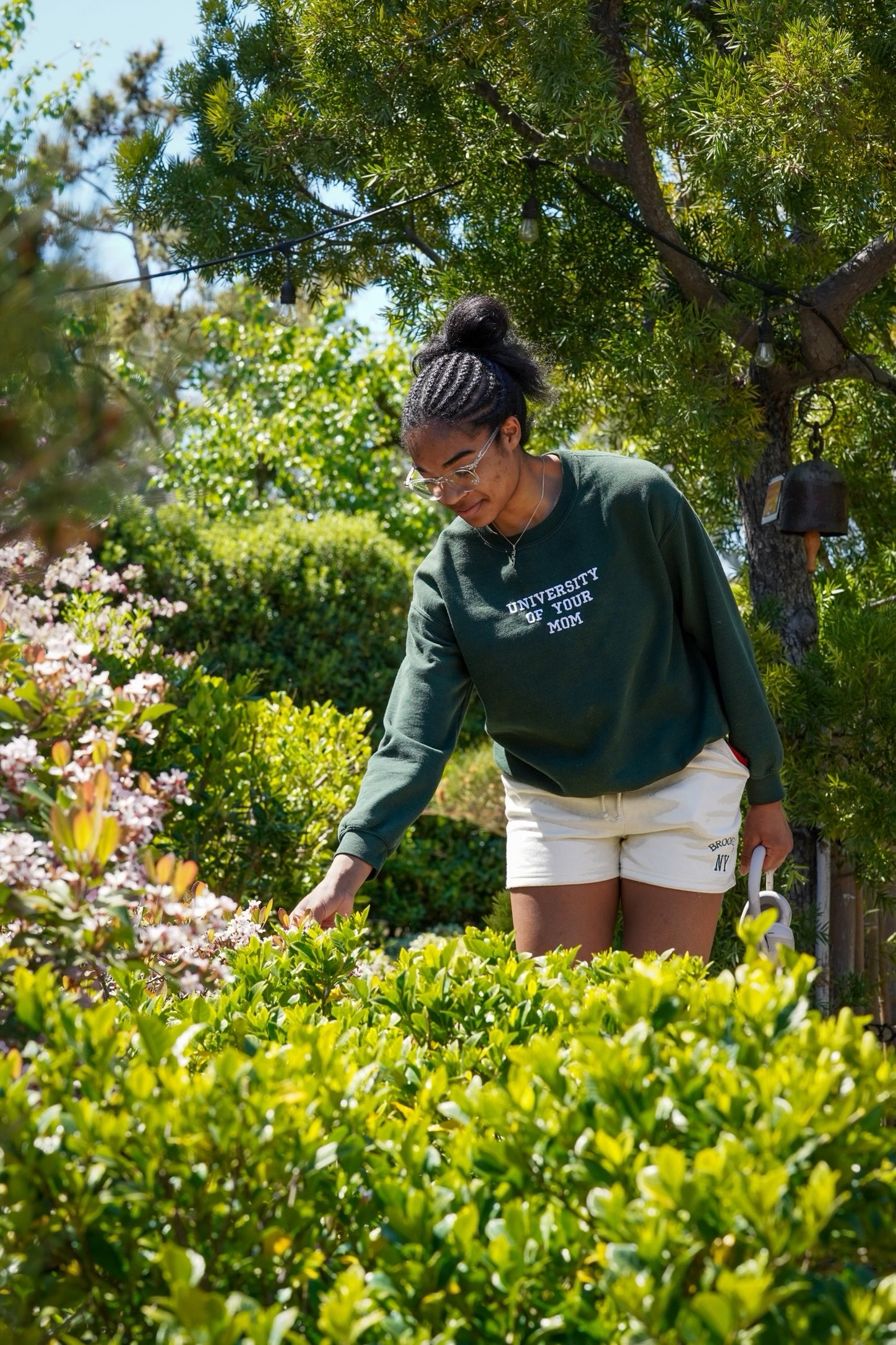  Sydney Woodley touches the flowers on the shrub. Photo by Kimberly Carrillo 