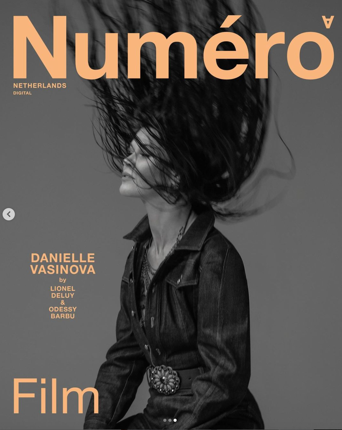 Magazine cover featuring a woman with black hair flying around her head, wearing a denim jacket and a belt with a decorative buckle.