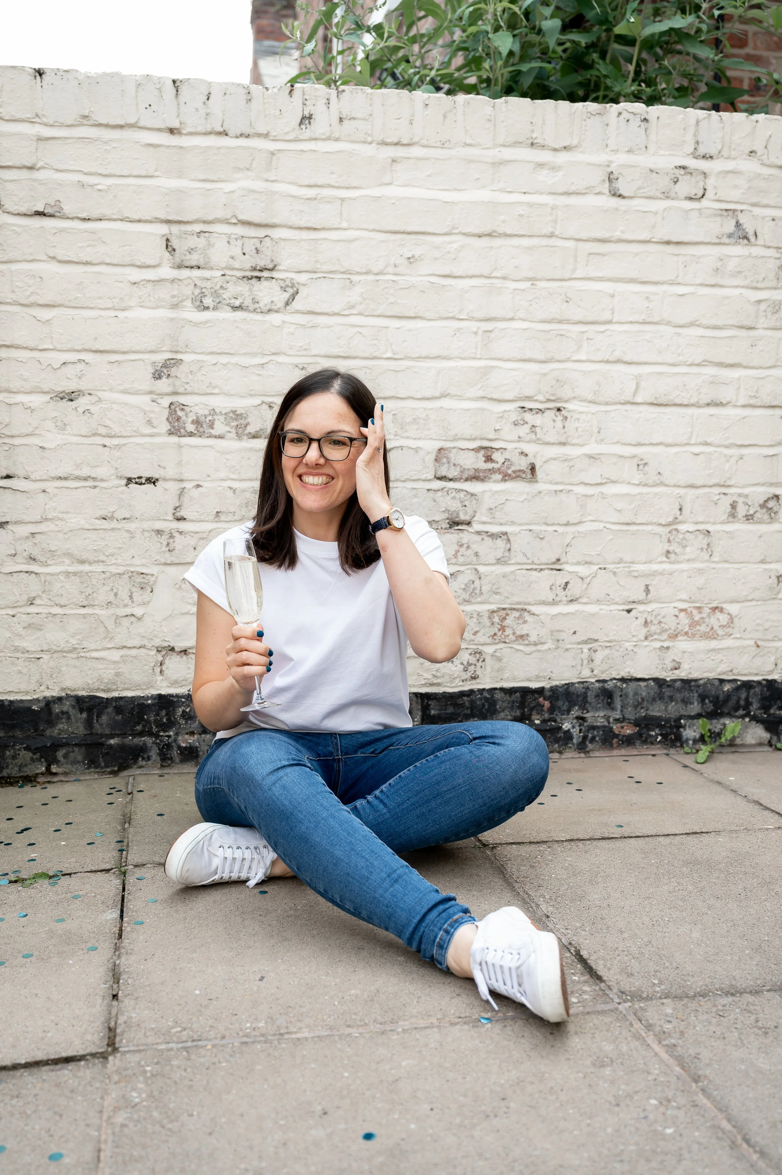 woman sitting on the floor with glass of prosecco in her hand